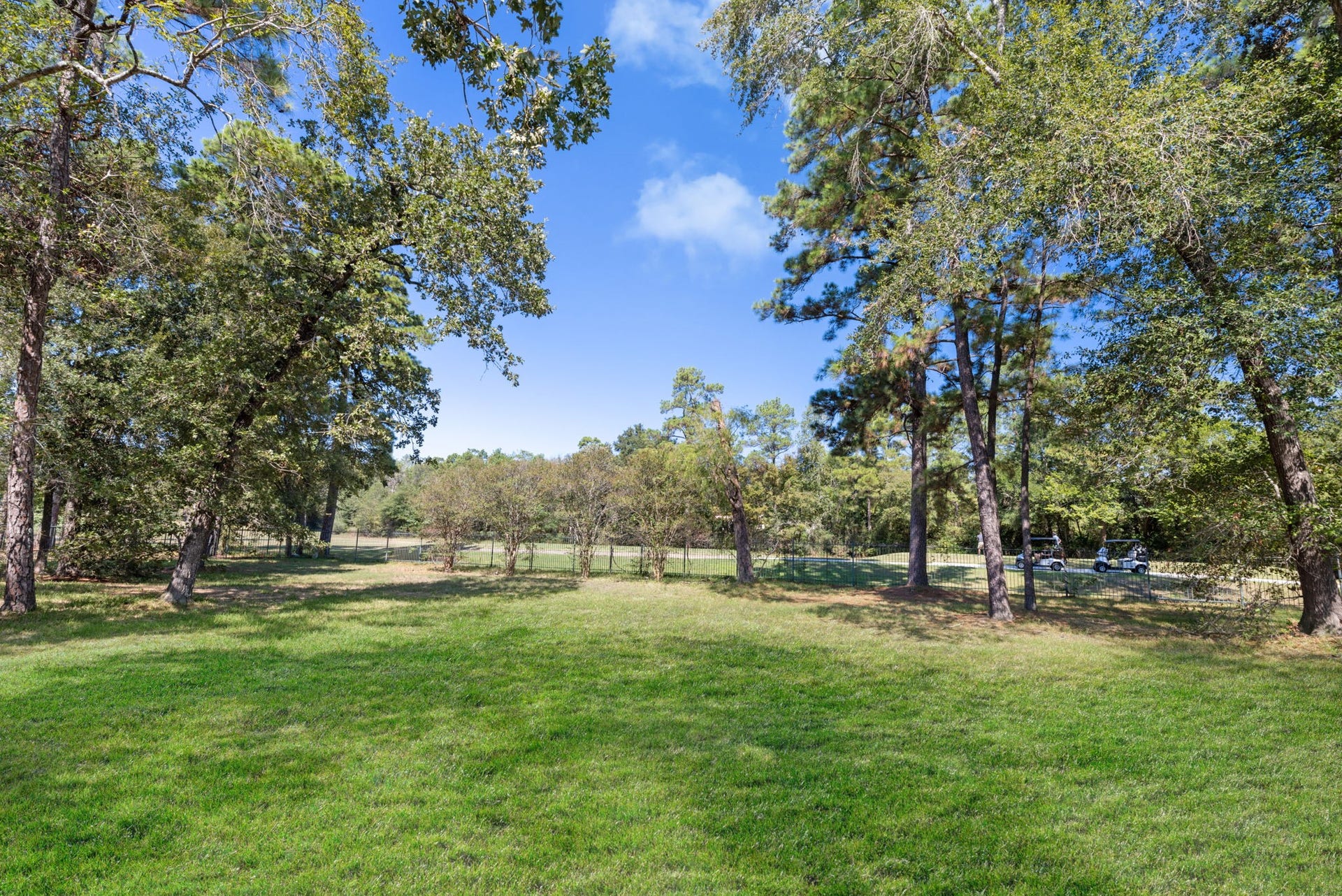 43 N Longspur Drive, The Woodlands, TX 77380 View from backyard to the Oaks Golf Course beyond the wrought iron fence.
