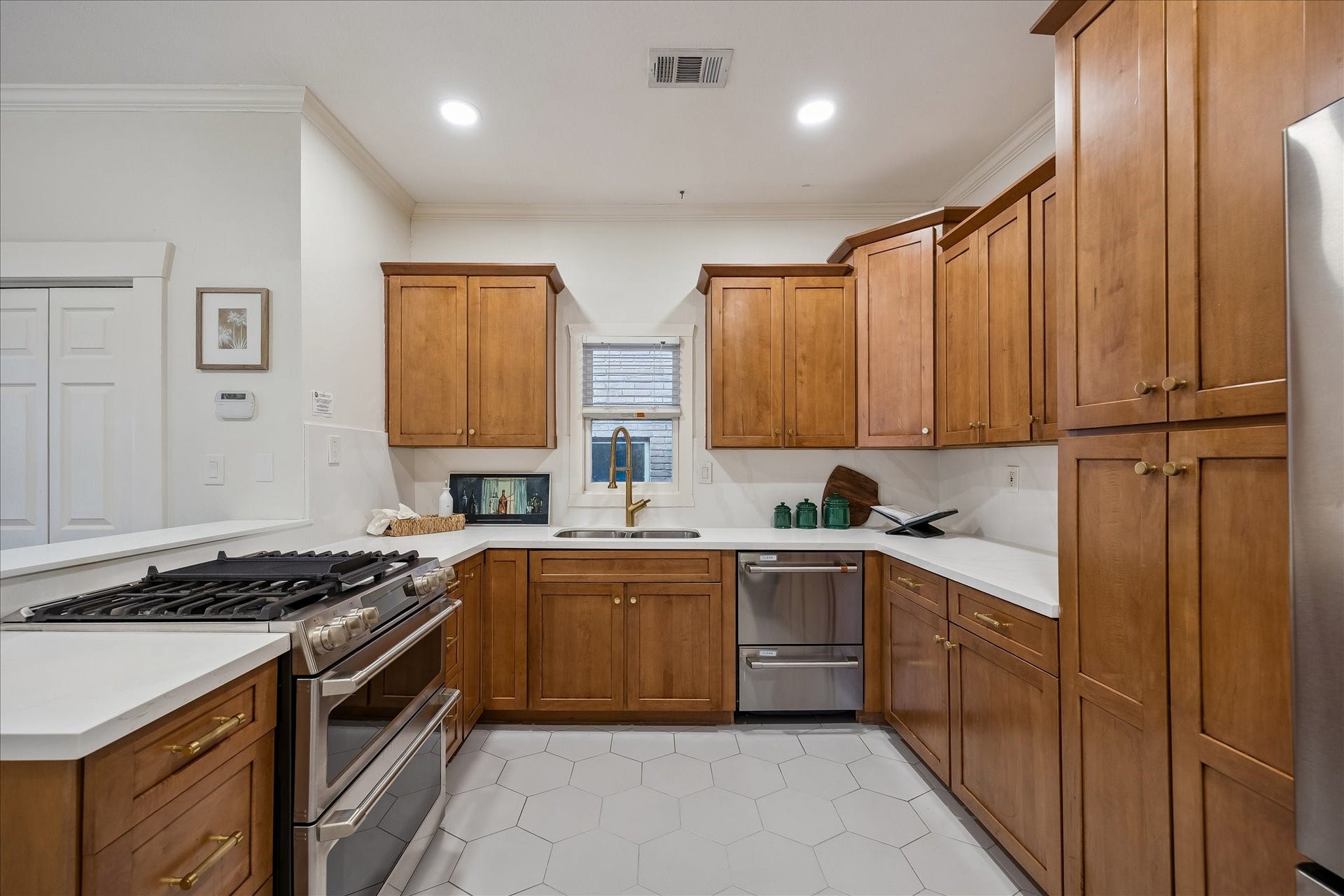 1635 Harvard Street, Houston, TX 77008 The kitchen with updated hex tile; stainless steel appliances; breakfast bar; and abundant cabinet space.