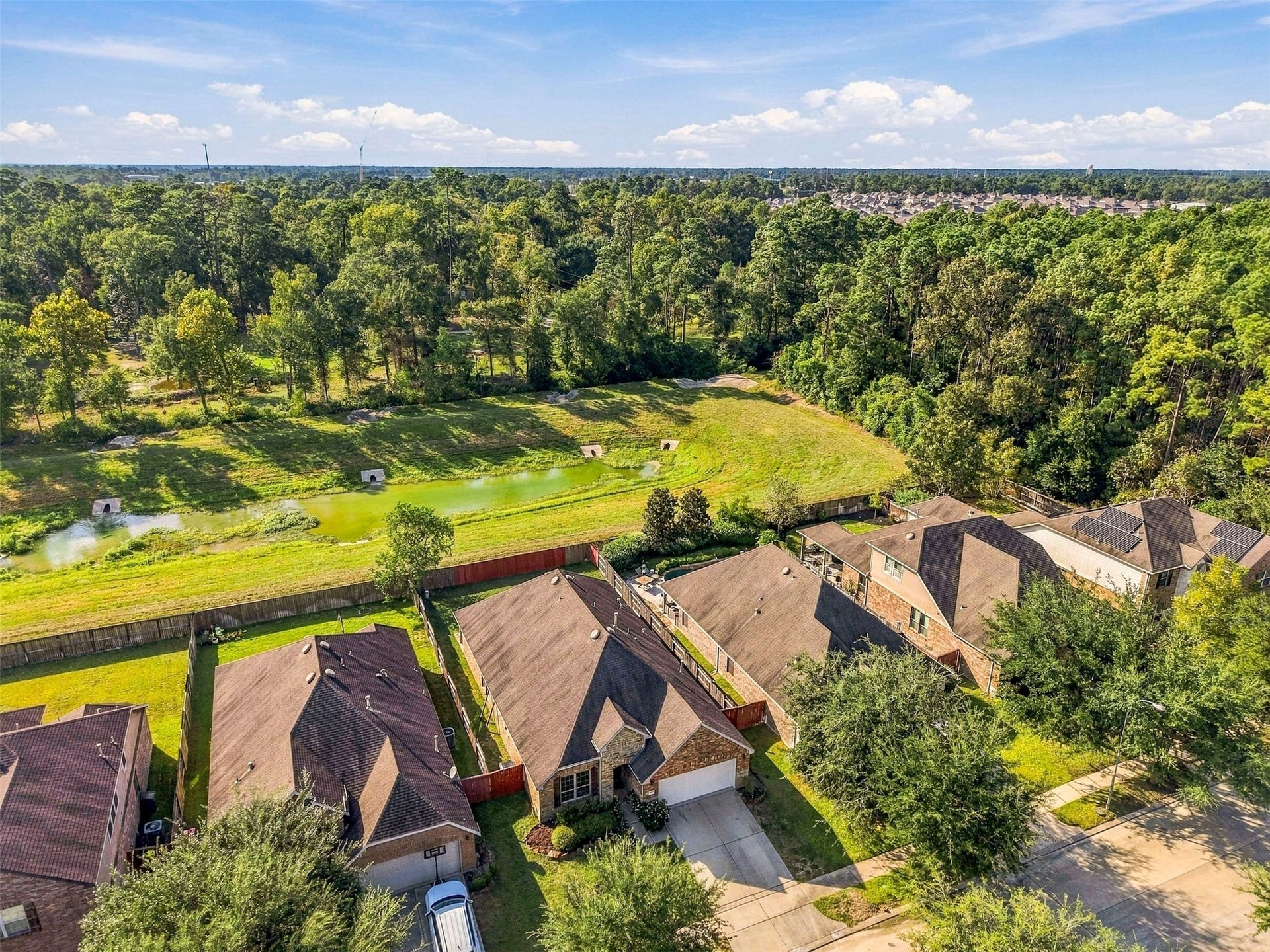 4557 Argonne Woods Drive, Porter, TX 77365 Charming homes with spacious backyards overlook a serene greenbelt and picturesque pond, offering a peaceful and private setting.