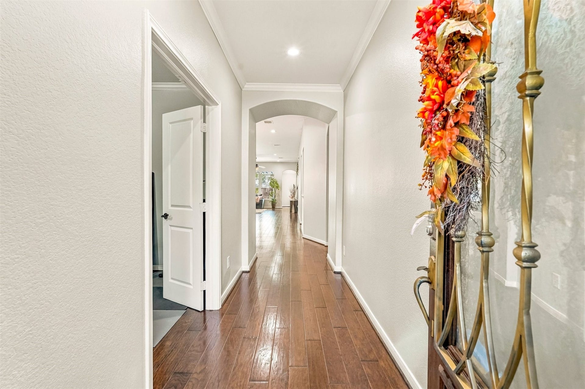 4557 Argonne Woods Drive, Porter, TX 77365 Inviting hallway with elegant wood flooring, leading to an open living space, enhanced by soft lighting and tasteful decor.