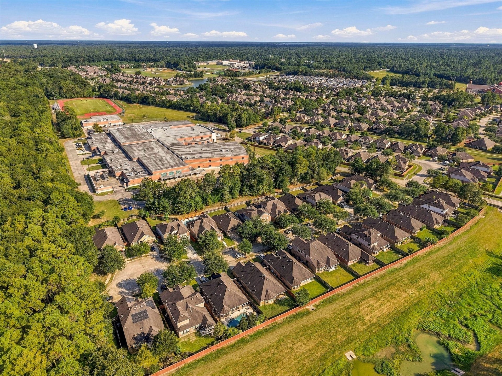 4557 Argonne Woods Drive, Porter, TX 77365 Charming suburban neighborhood nestled next to lush greenery, featuring well-maintained homes and a nearby school with athletic facilities. Ideal for families seeking a peaceful community setting.
