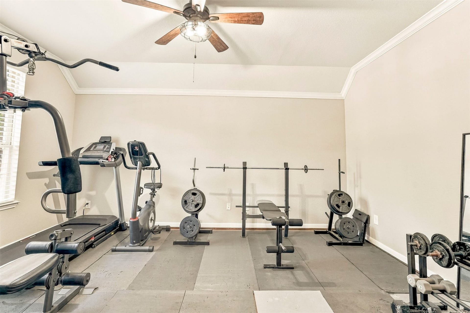 4557 Argonne Woods Drive, Porter, TX 77365 Spacious home gym equipped with a treadmill, exercise bike, bench, and weight set, perfect for fitness enthusiasts.