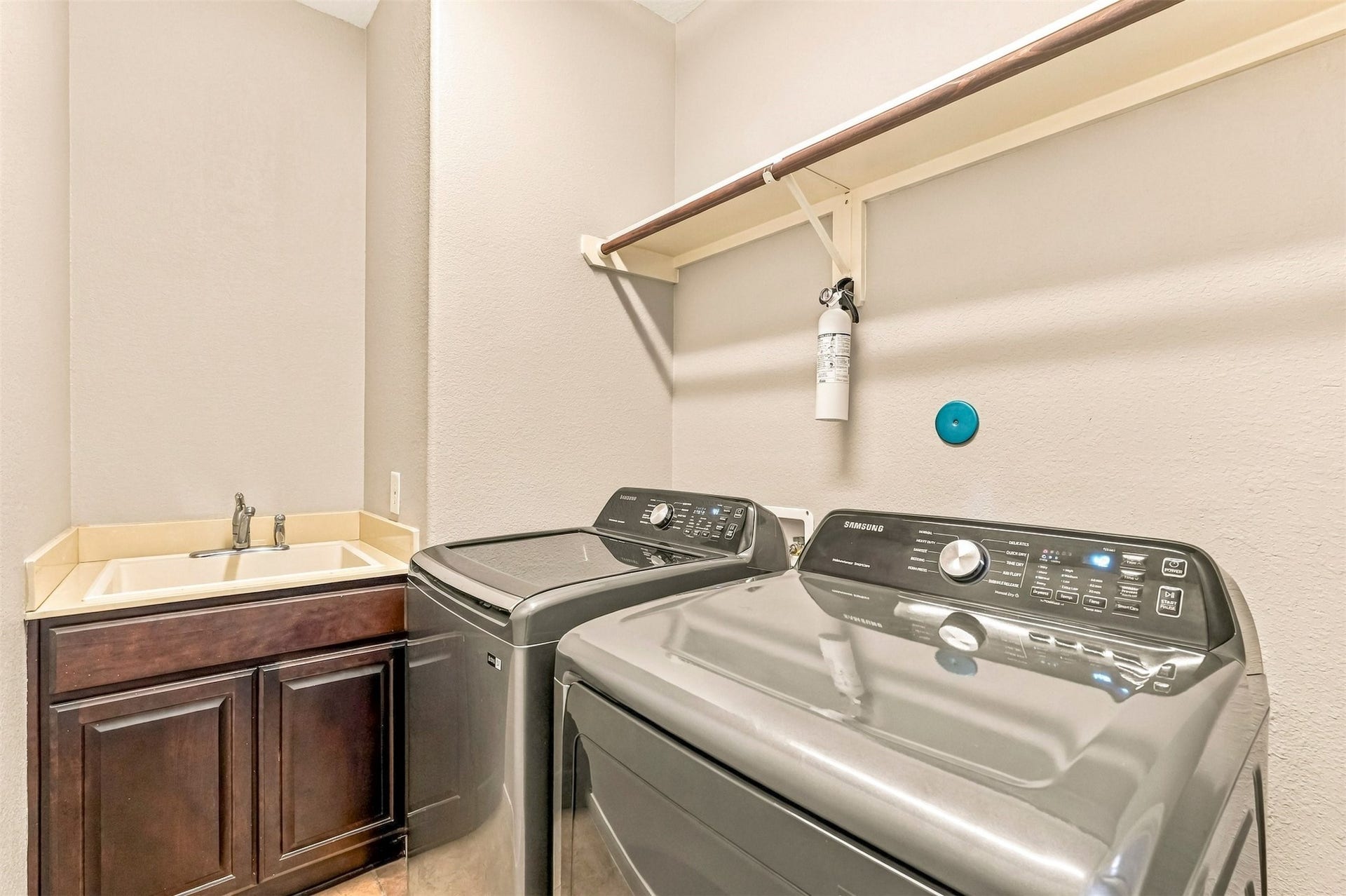 4557 Argonne Woods Drive, Porter, TX 77365 Spacious laundry room with modern Samsung washer and dryer, ample countertop space, and convenient storage cabinets.