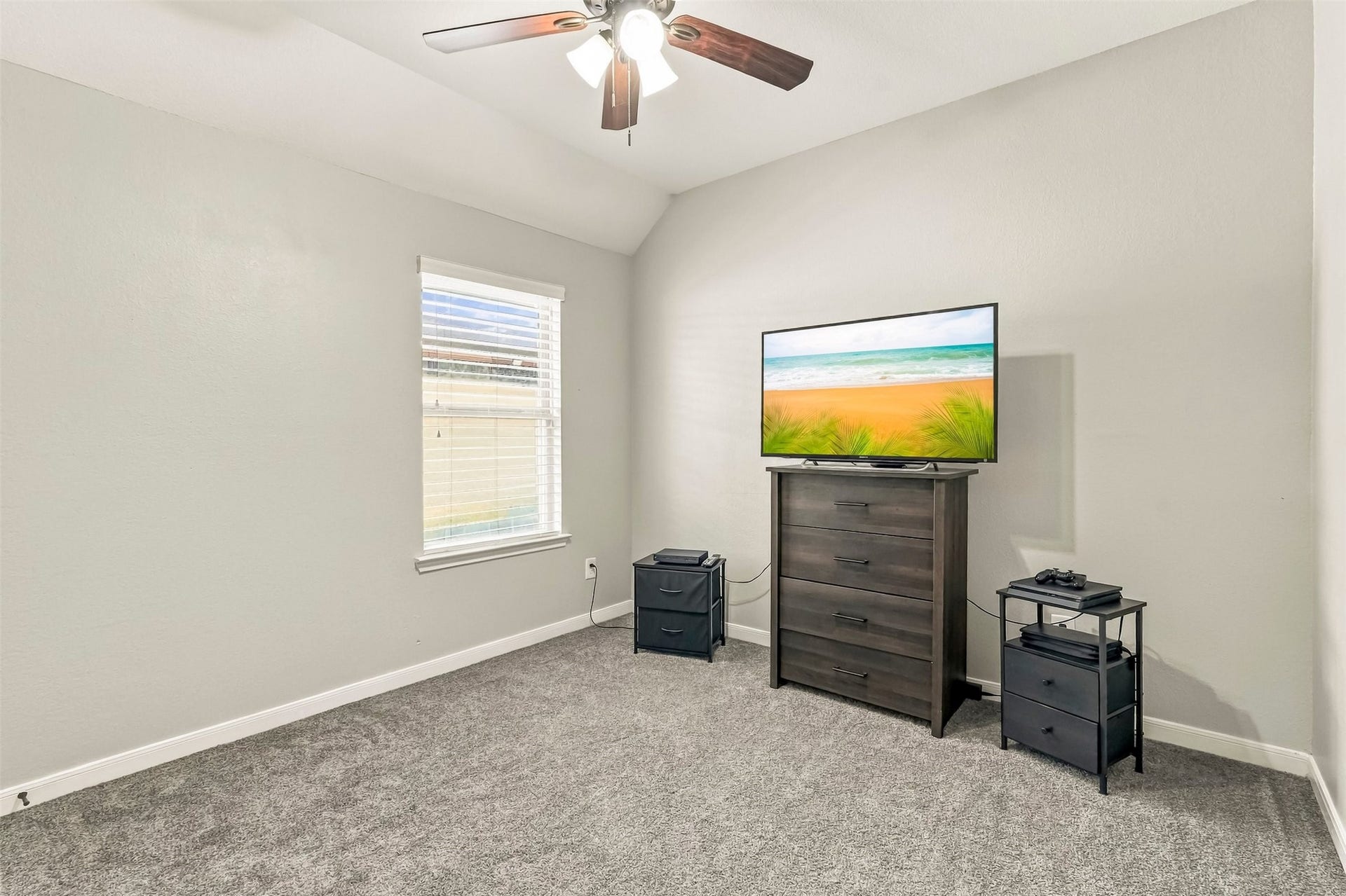 4557 Argonne Woods Drive, Porter, TX 77365 Cozy bedroom featuring soft carpeting, a ceiling fan, and ample natural light from a well-placed window.