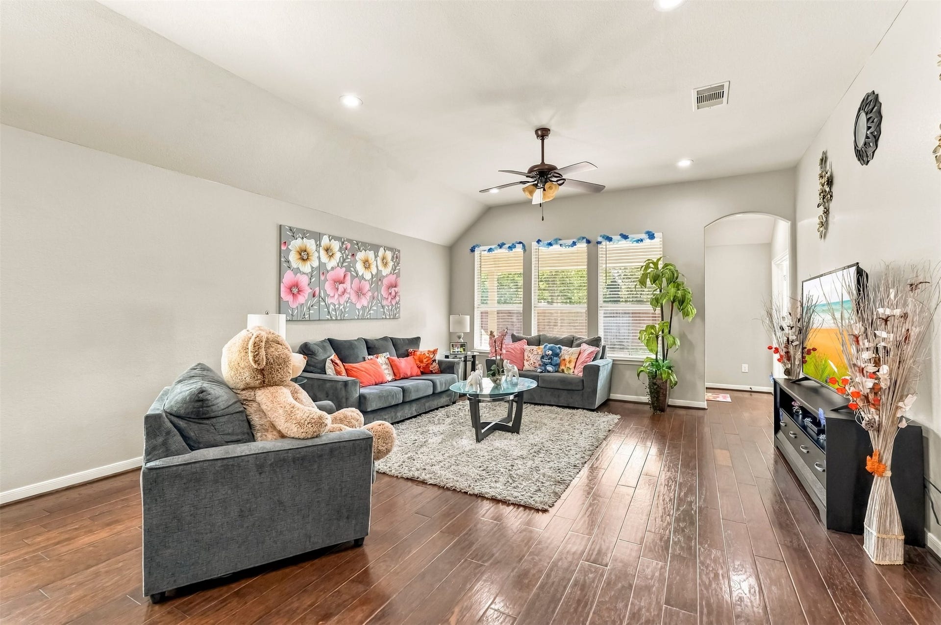 4557 Argonne Woods Drive, Porter, TX 77365 Spacious living room with elegant hardwood floors, abundant natural light, and stylish decor, perfect for relaxation and entertainment.
