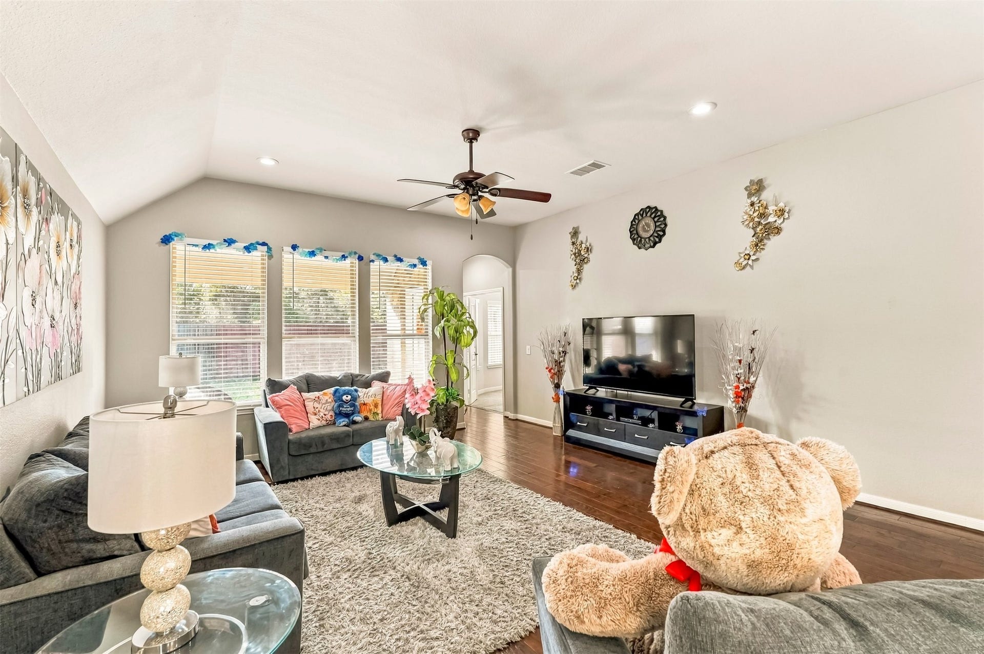 4557 Argonne Woods Drive, Porter, TX 77365 Bright and inviting living room with vaulted ceilings, hardwood floors, and abundant natural light from large windows, perfect for relaxation and entertainment.