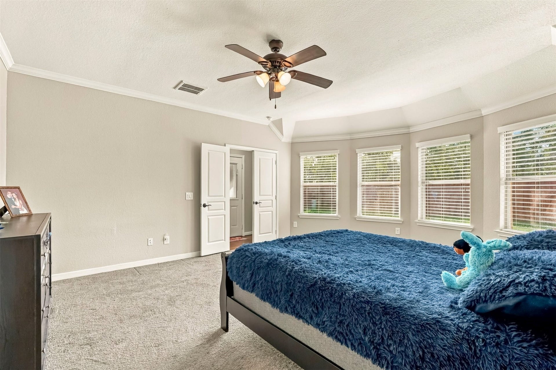 4557 Argonne Woods Drive, Porter, TX 77365 Spacious bedroom with soft carpeting, large windows for natural light, and a ceiling fan for comfort.