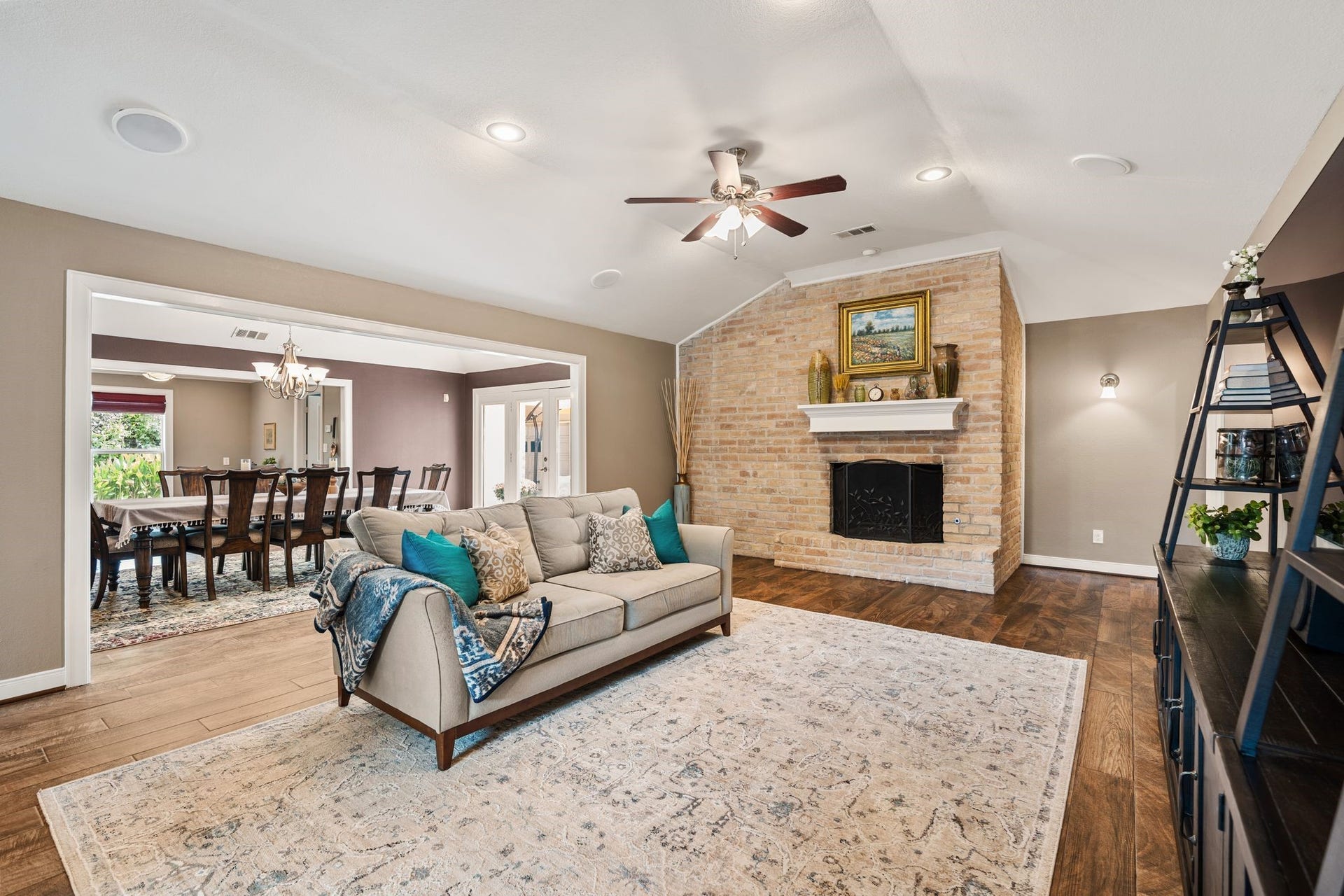 11519 Lakeside Place Drive, Houston, TX 77077 Spacious living area with a cozy brick fireplace and seamless flow into the dining room, perfect for gatherings.
