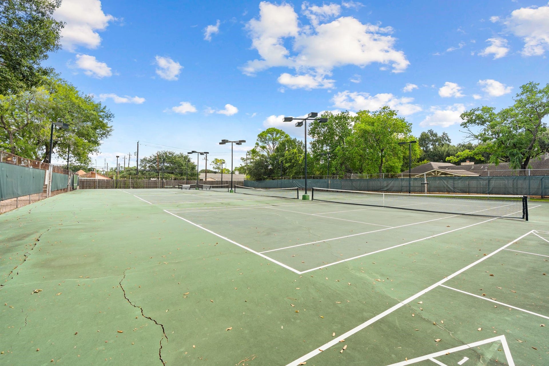 11519 Lakeside Place Drive, Houston, TX 77077 Expansive tennis courts surrounded by lush greenery, perfect for sports enthusiasts seeking an active lifestyle.