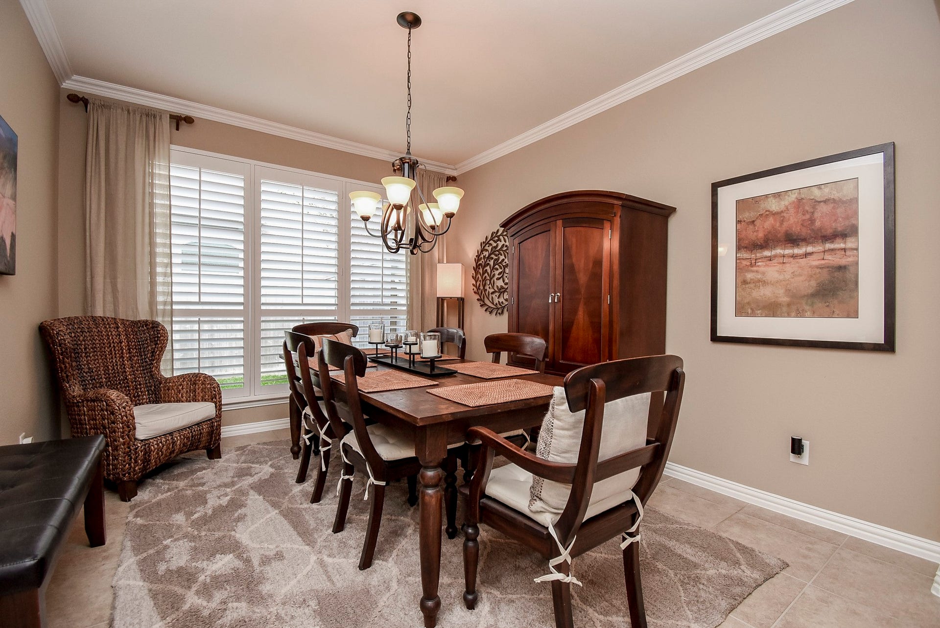 Open formal dining room with crown molding and shutters.