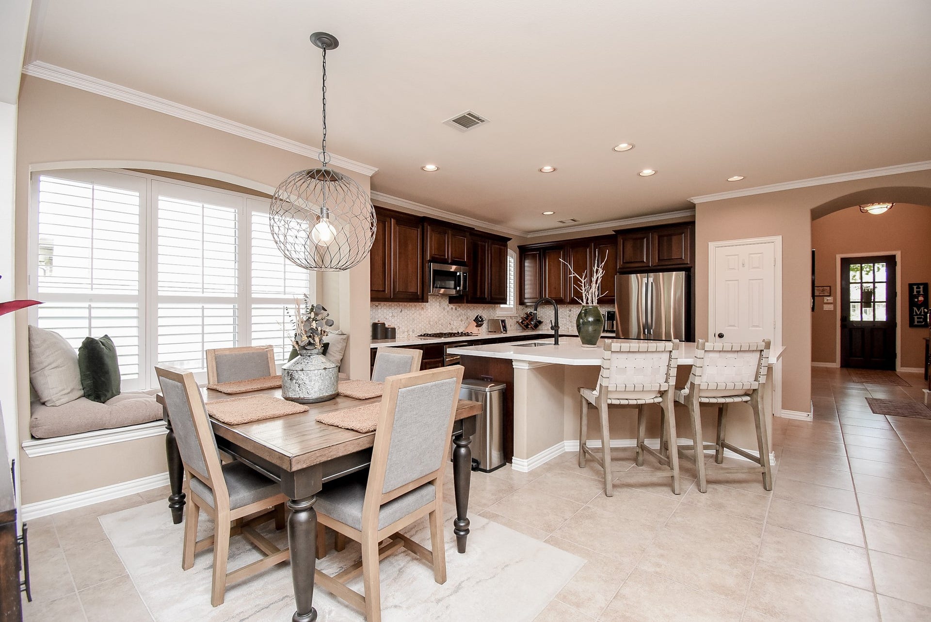 Back view looking into kitchen which shows the well planned open concept and cozy window seat and cushion