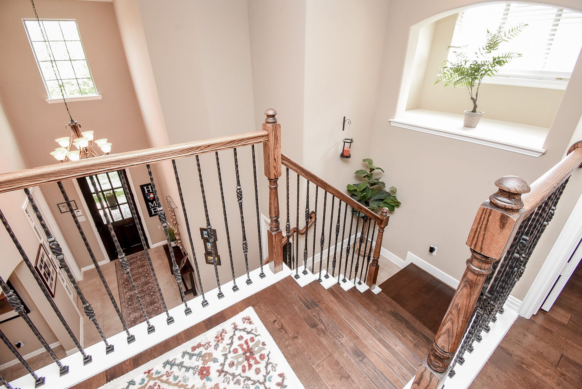 Second floor landing with beautiful wood/wrought iron spindles compliment this gorgeous home with wood flooring, custom window coverings and lots of natural light.