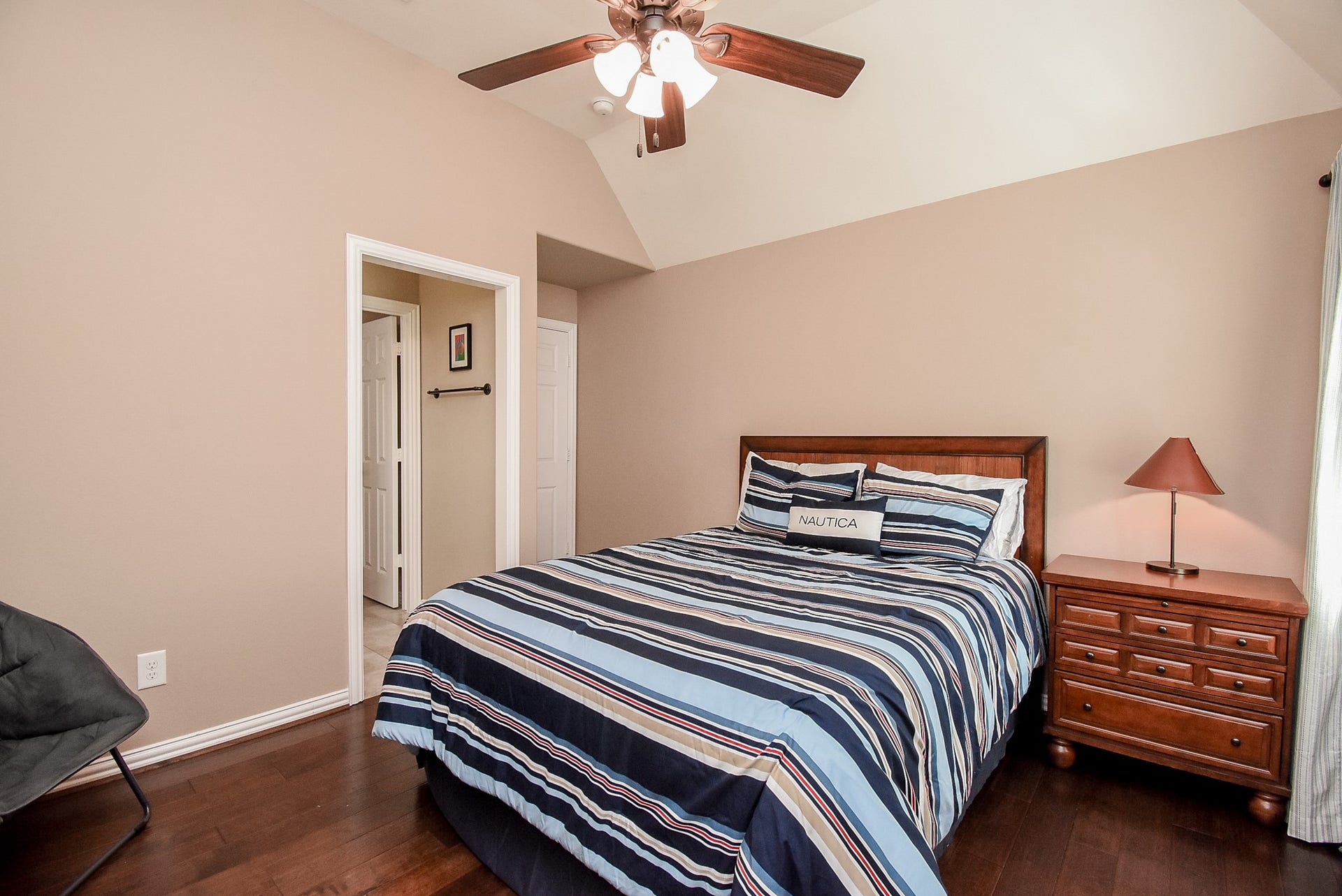 Secondary bedroom also with wood flooring, tray ceiling and fan.