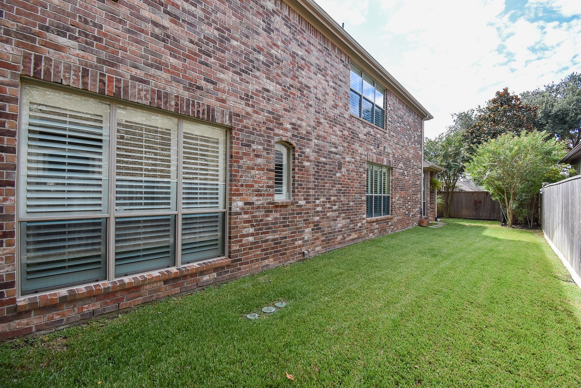 Front view looking back at the large side yard. Worth noting that this lot has plenty of space between neighbors which is perfect for privacy as well as natural light.