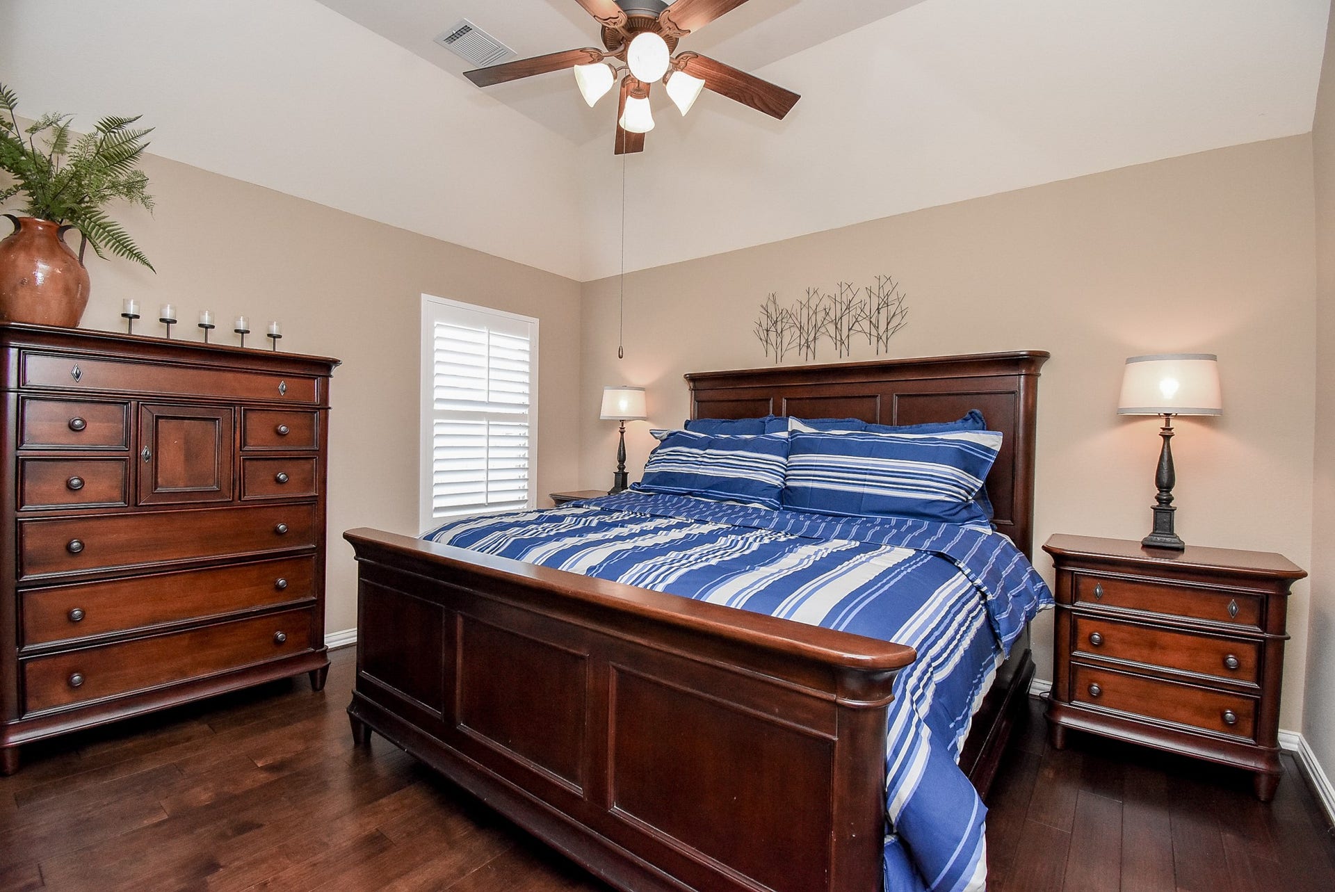 Large secondary bedroom with wood flooring, tray ceiling and ceiling fan all compliment this room nicely.