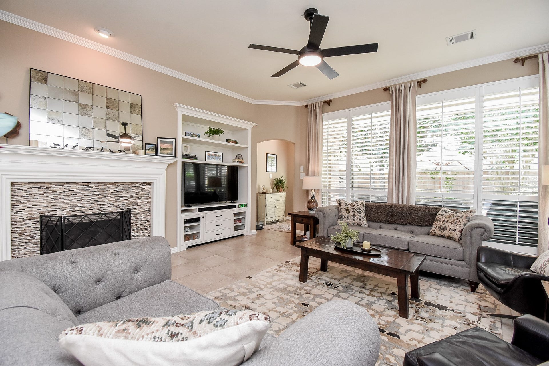 Large den with gas log fireplace, tile surround and custom built in shelf unit. This home is full of natural light and flows so well.