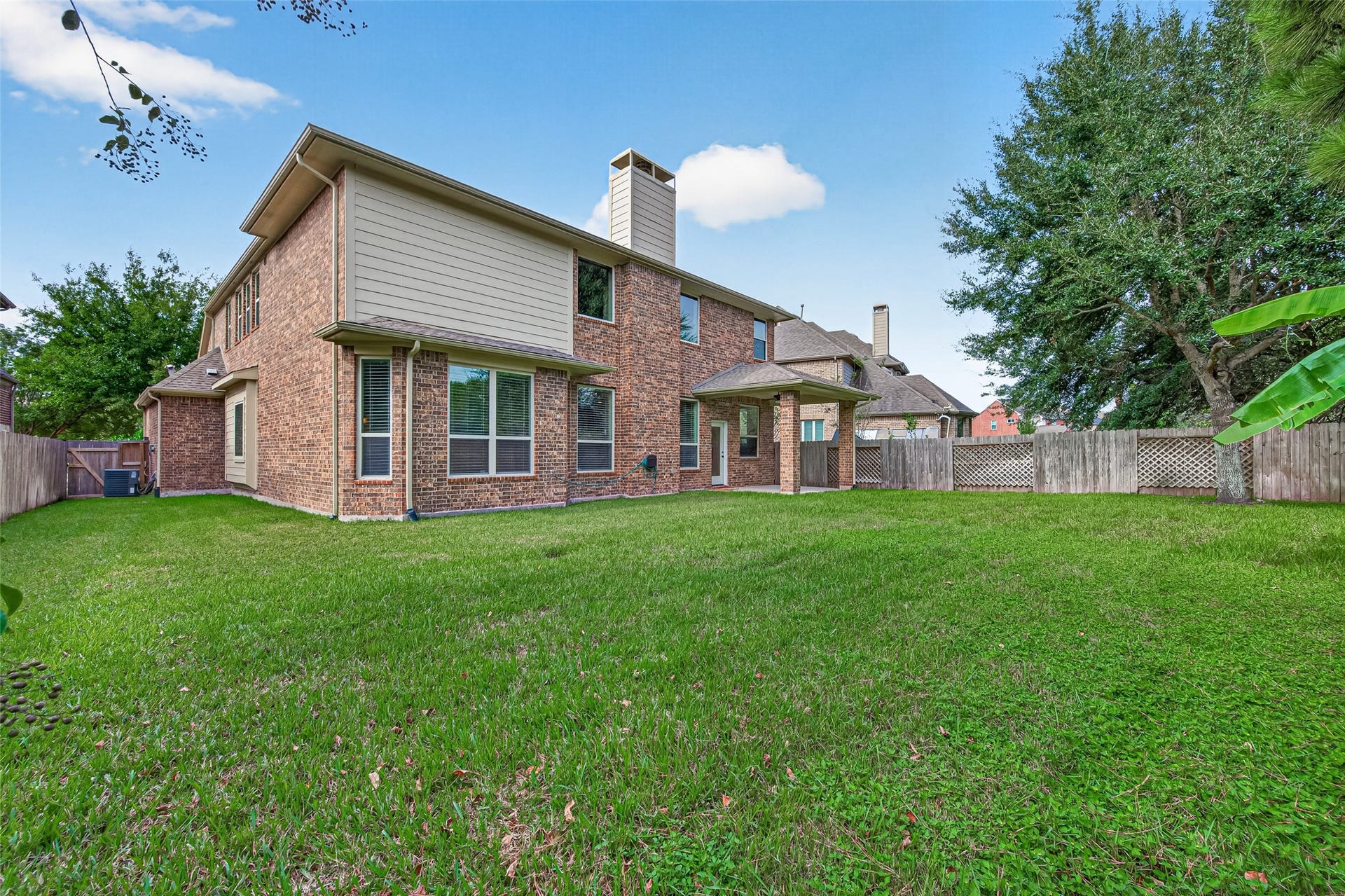 Large lawn with brick fence and sprinklers, room for outdoor living