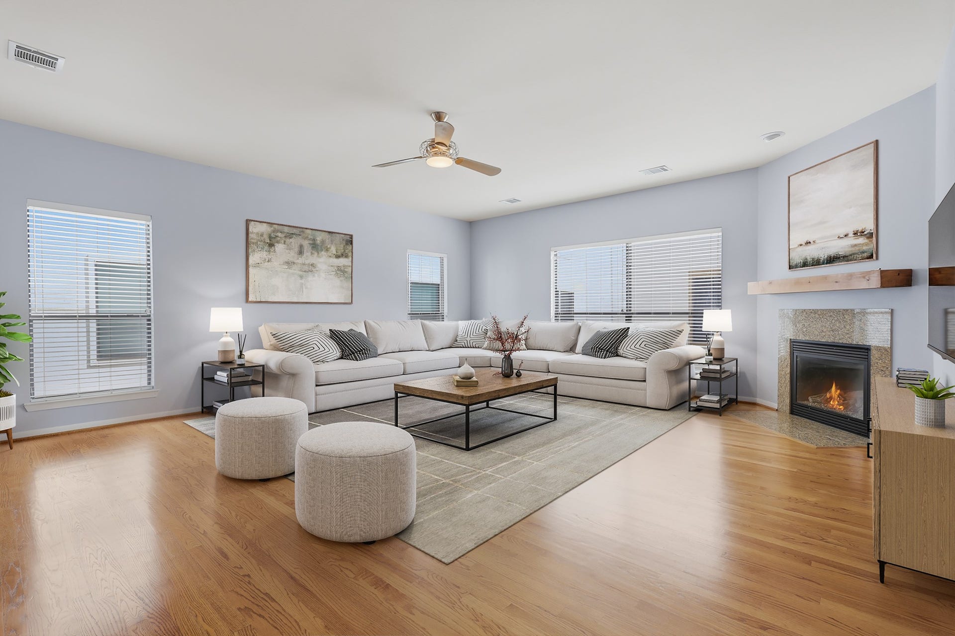 Virtually staged living area highlighting the hardwood floors, fireplace, and seamless connection to the kitchen and dining spaces.