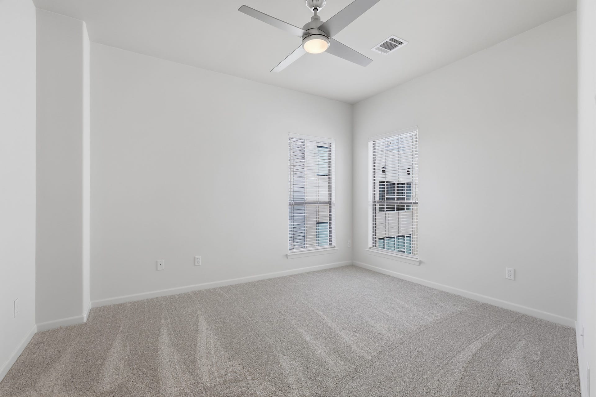 Third bedroom with neutral finishes and flexibility for guests, work, or additional living space.