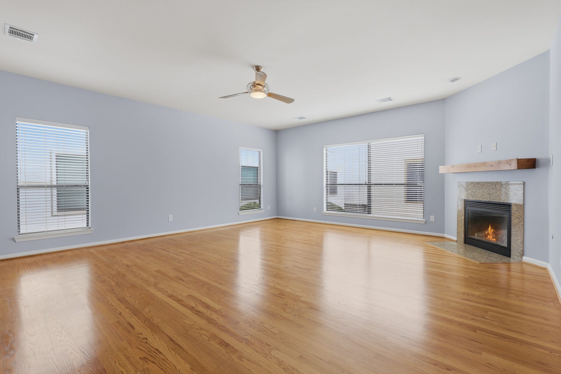 Additional view of the living area highlighting the hardwood floors, abundant natural light, and open-concept design.