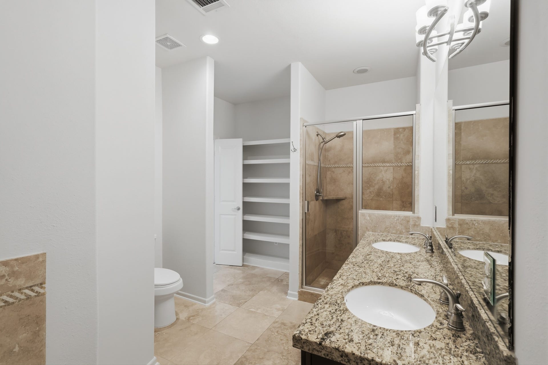 Primary en suite bathroom featuring dual vanities, a soaking tub, and separate shower.