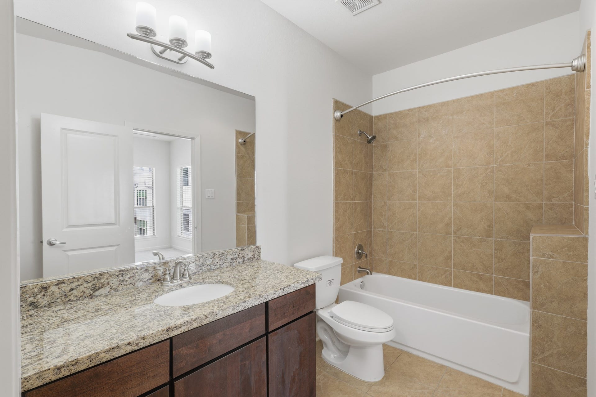 Full en suite bathroom serving the third bedroom with tub and shower combination.