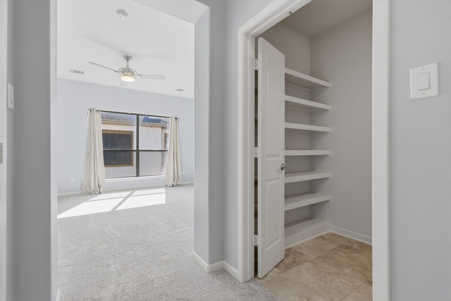Built-in shelving in the primary bath provides additional storage for the primary suite