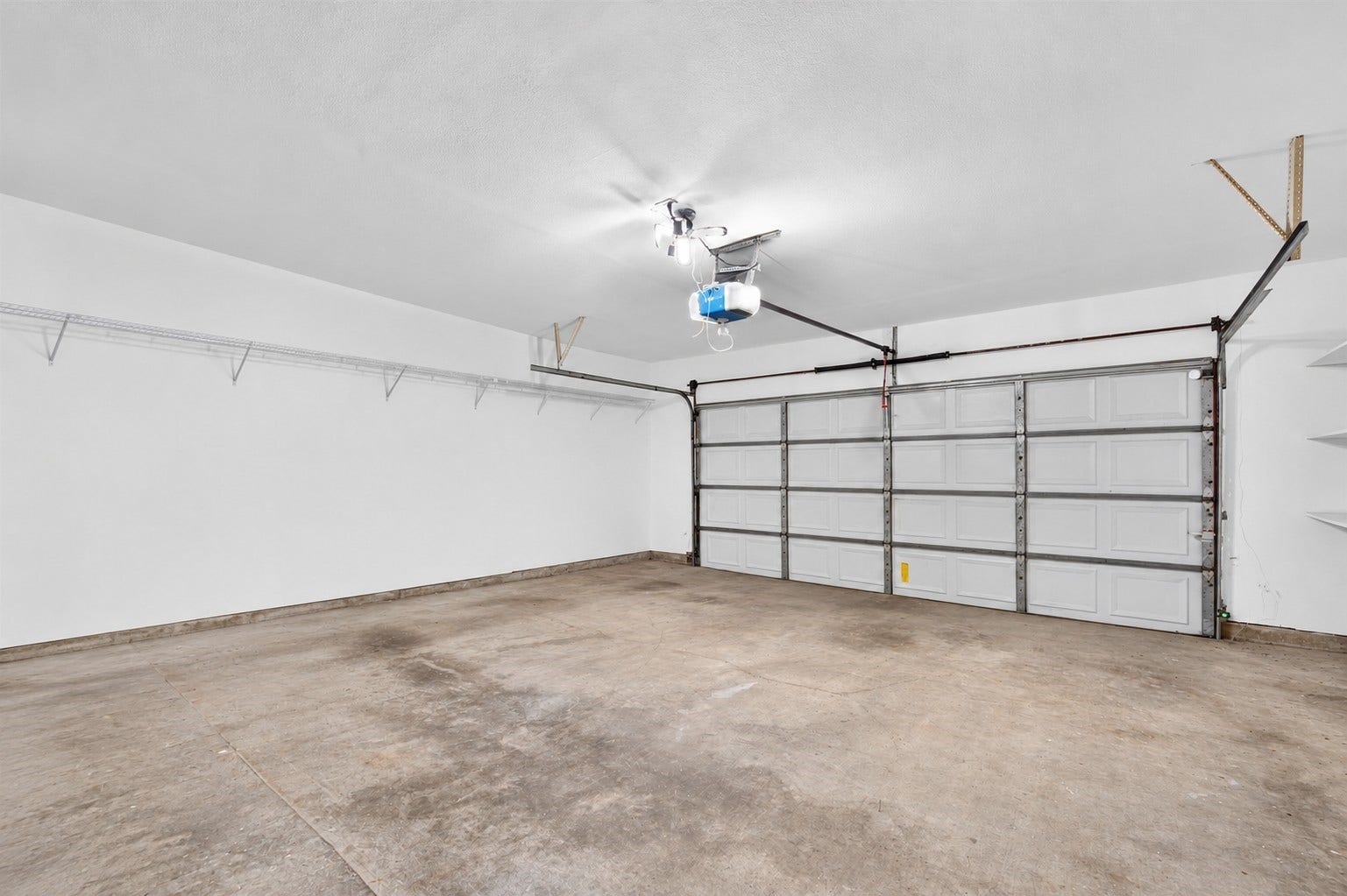 2220 Bering Drive, #12, Houston, TX 77057 Attached two-car garage with an automatic door opener and storage shelving.