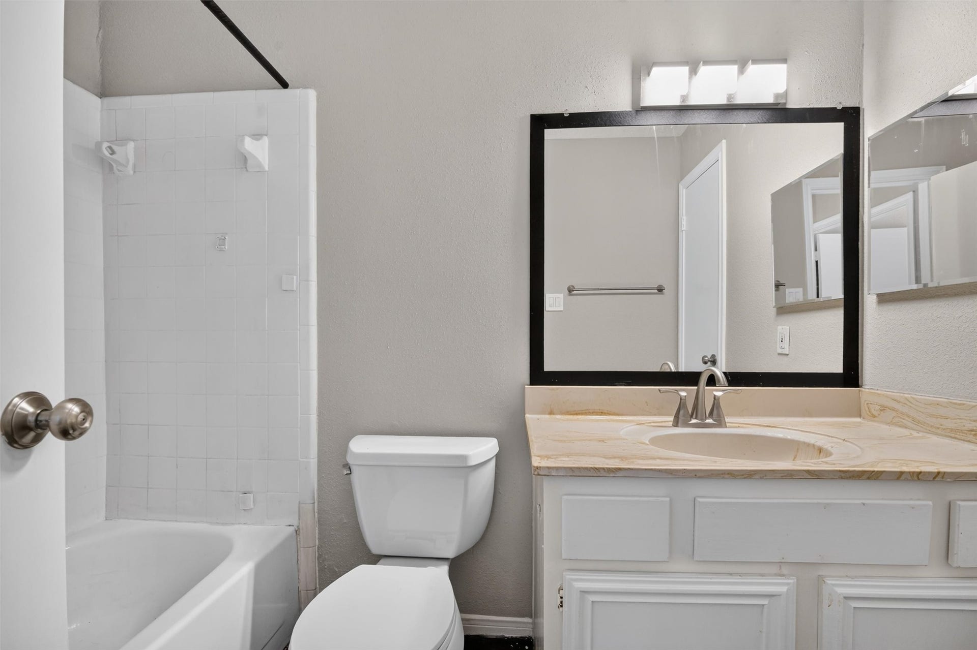 2220 Bering Drive, #12, Houston, TX 77057 Secondary full bathroom with a tub and shower combination, vanity storage, and a framed mirror.