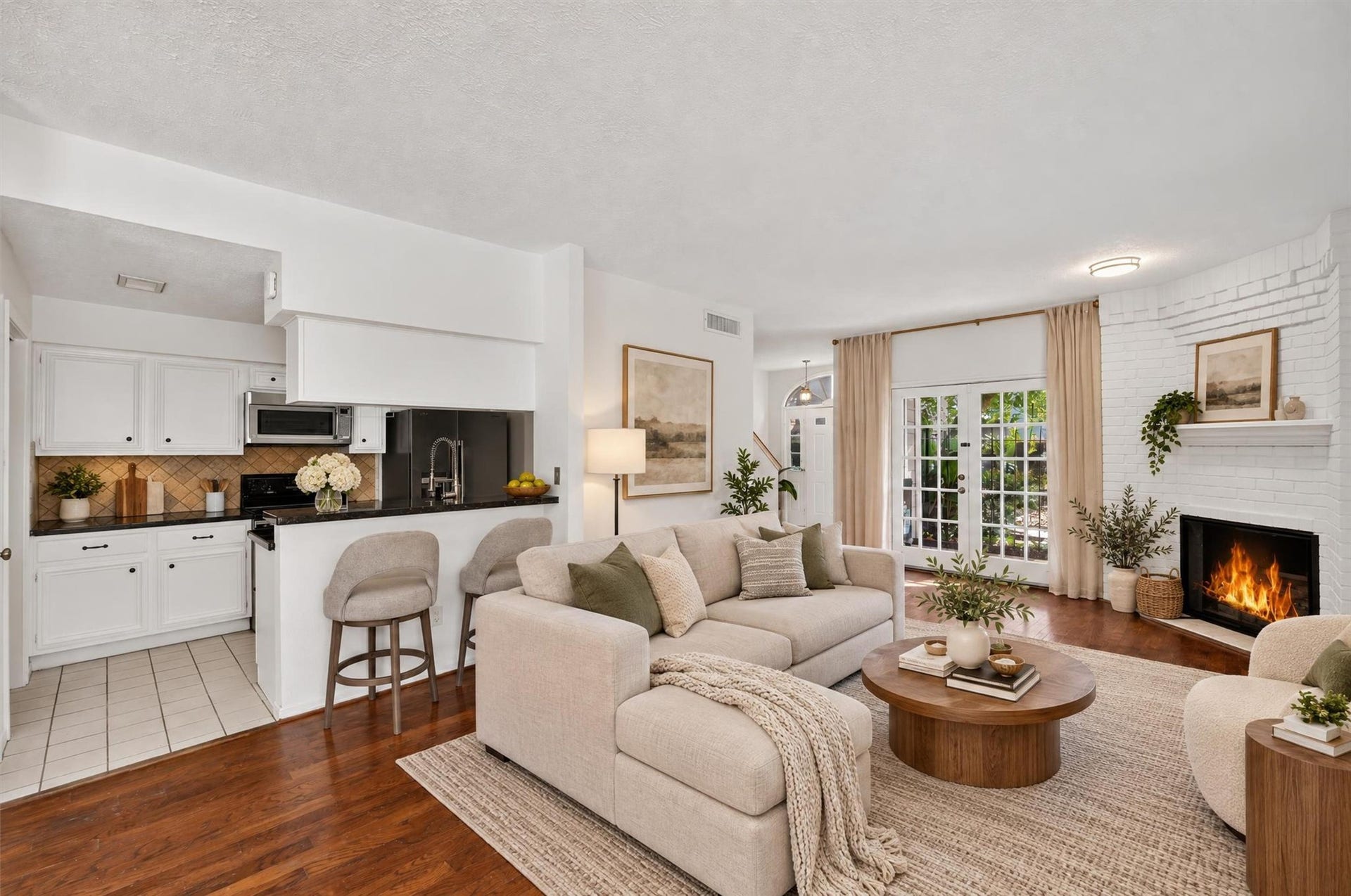 2220 Bering Drive, #12, Houston, TX 77057 Open living area with a fireplace, breakfast bar, and French doors leading to the patio. Virtually staged.
