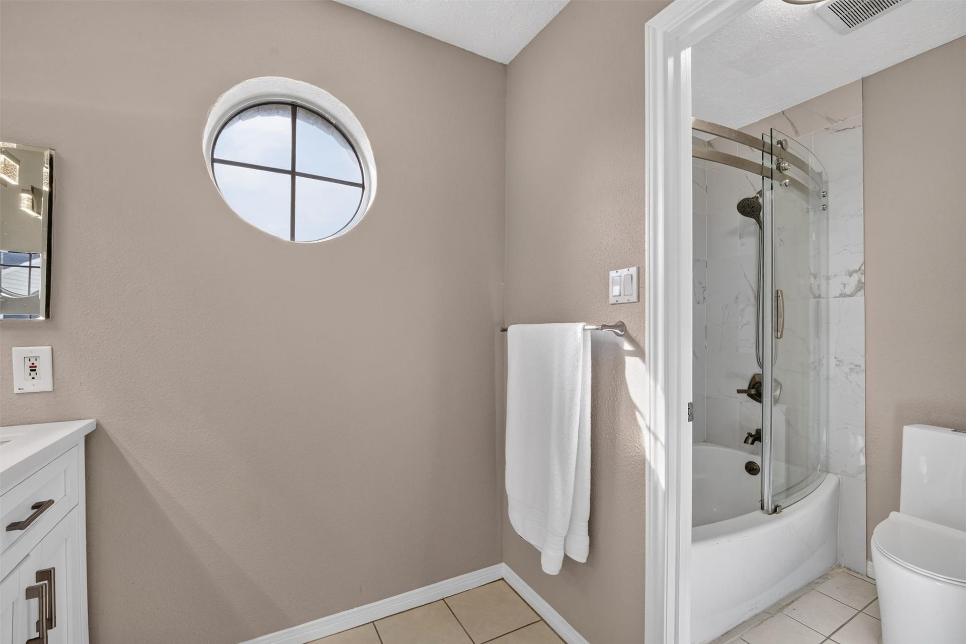 2220 Bering Drive, #12, Houston, TX 77057 Primary bathroom featuring a glass-enclosed shower and a distinctive round window.