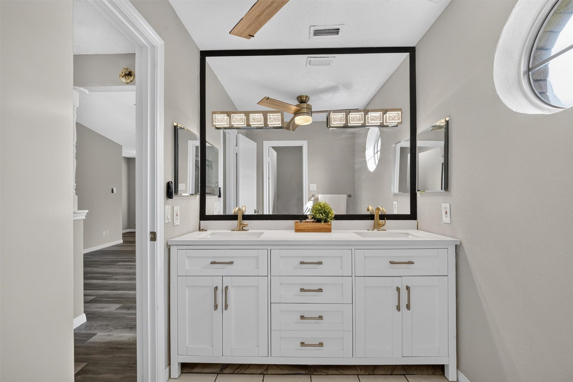 2220 Bering Drive, #12, Houston, TX 77057 Updated primary bathroom vanity featuring dual sinks, a spacious countertop, a large framed mirror, and ample cabinet storage.