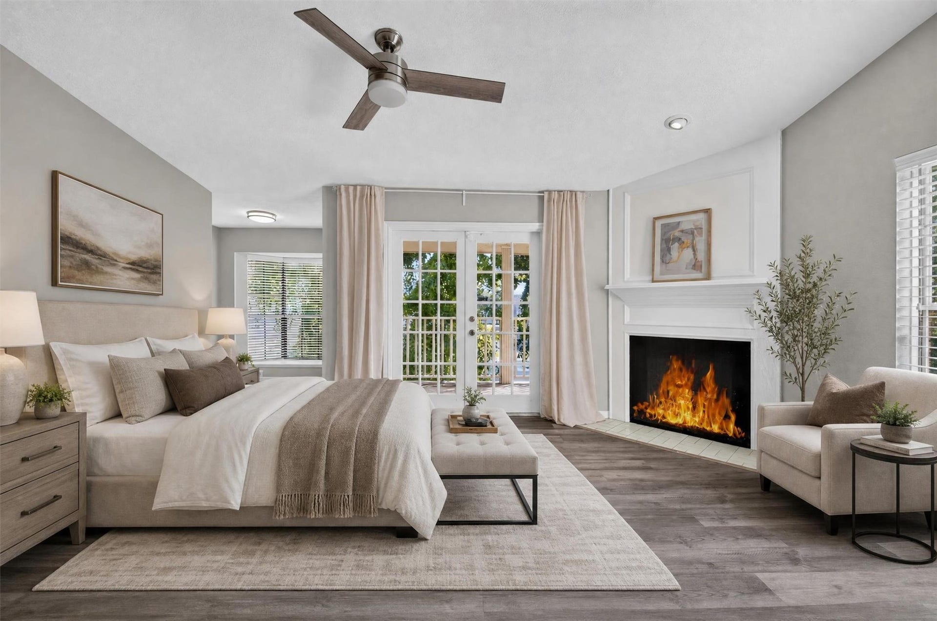 2220 Bering Drive, #12, Houston, TX 77057 Spacious primary suite featuring a fireplace and French doors opening to a covered balcony overlooking mature trees and the community pool. Virtually staged.