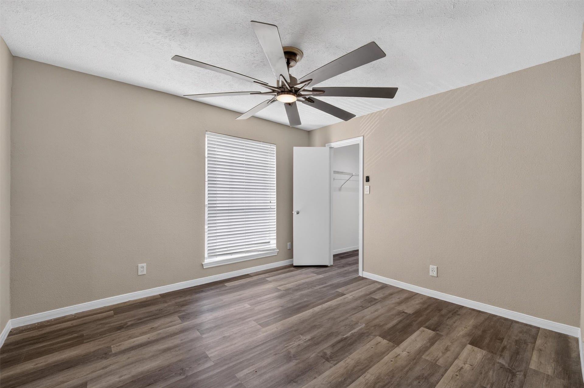 2220 Bering Drive, #12, Houston, TX 77057 Unstaged additional bedroom showing its layout, ceiling fan, and wood-look flooring.