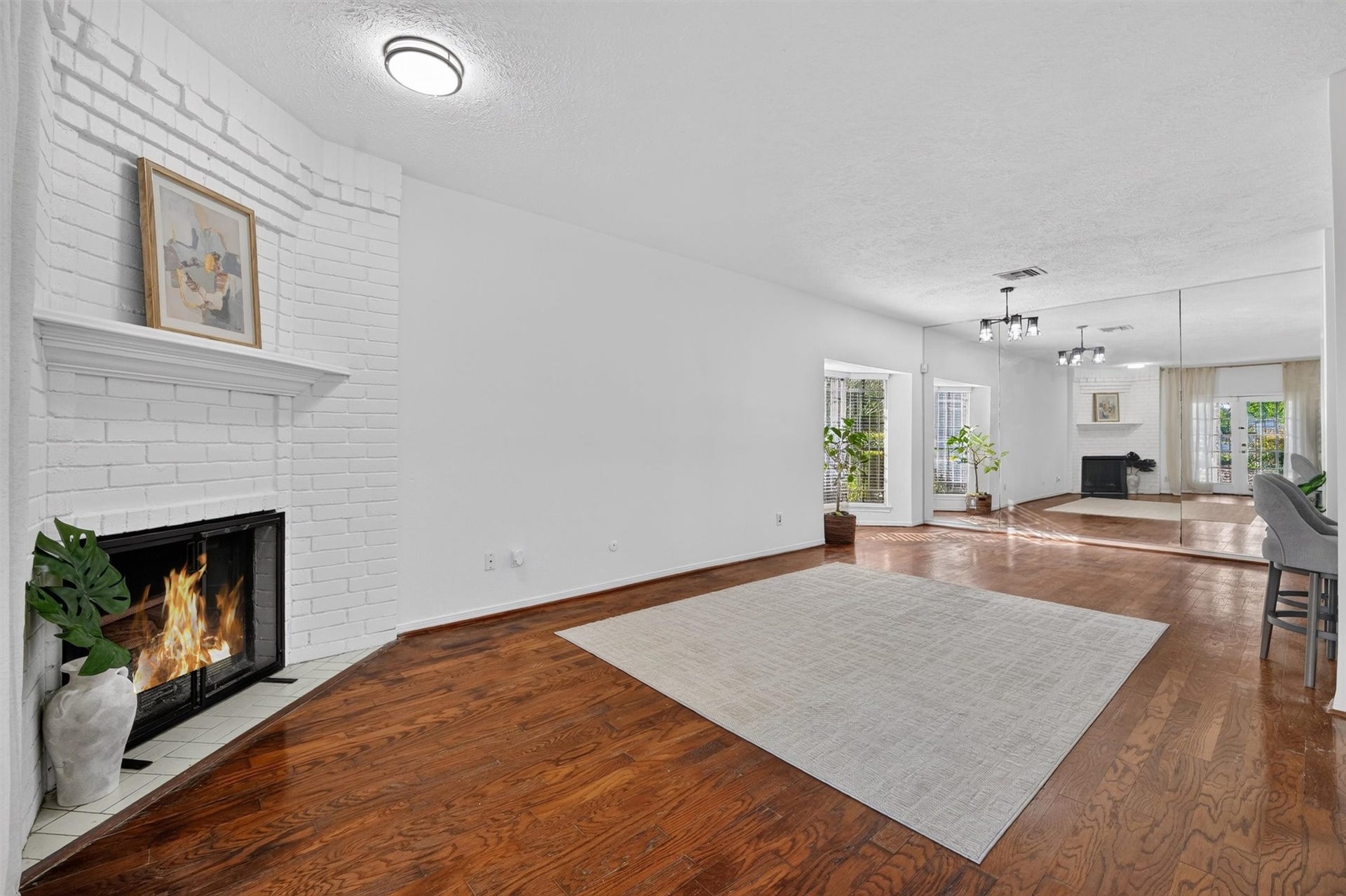 2220 Bering Drive, #12, Houston, TX 77057 Unstaged living room showing the fireplace, flooring, and open connection to the dining area.