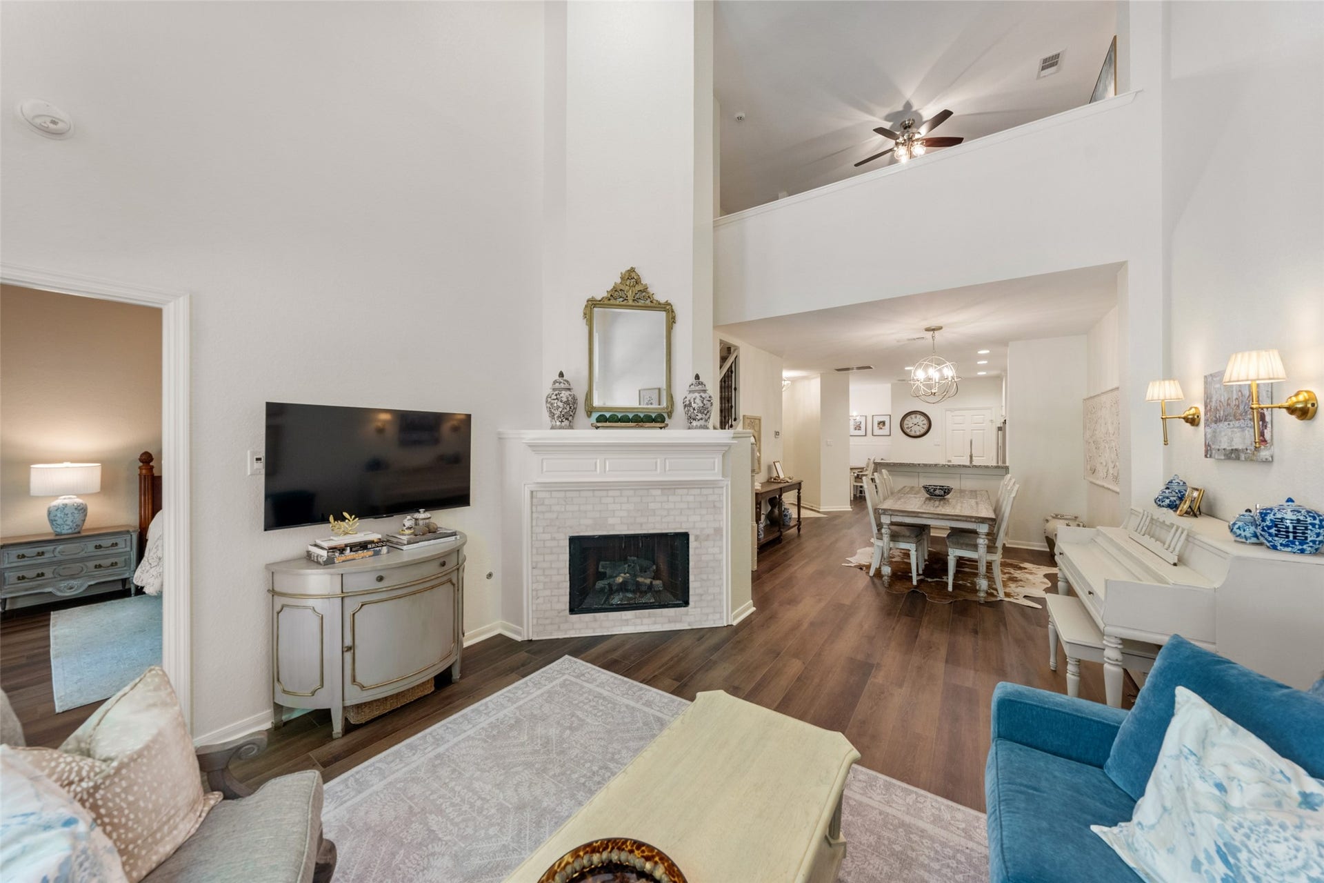 34 Alderon Woods Place, The Woodlands, TX 77382 Charming living area with high ceilings, elegant fireplace, and open layout leading to a cozy dining space.
