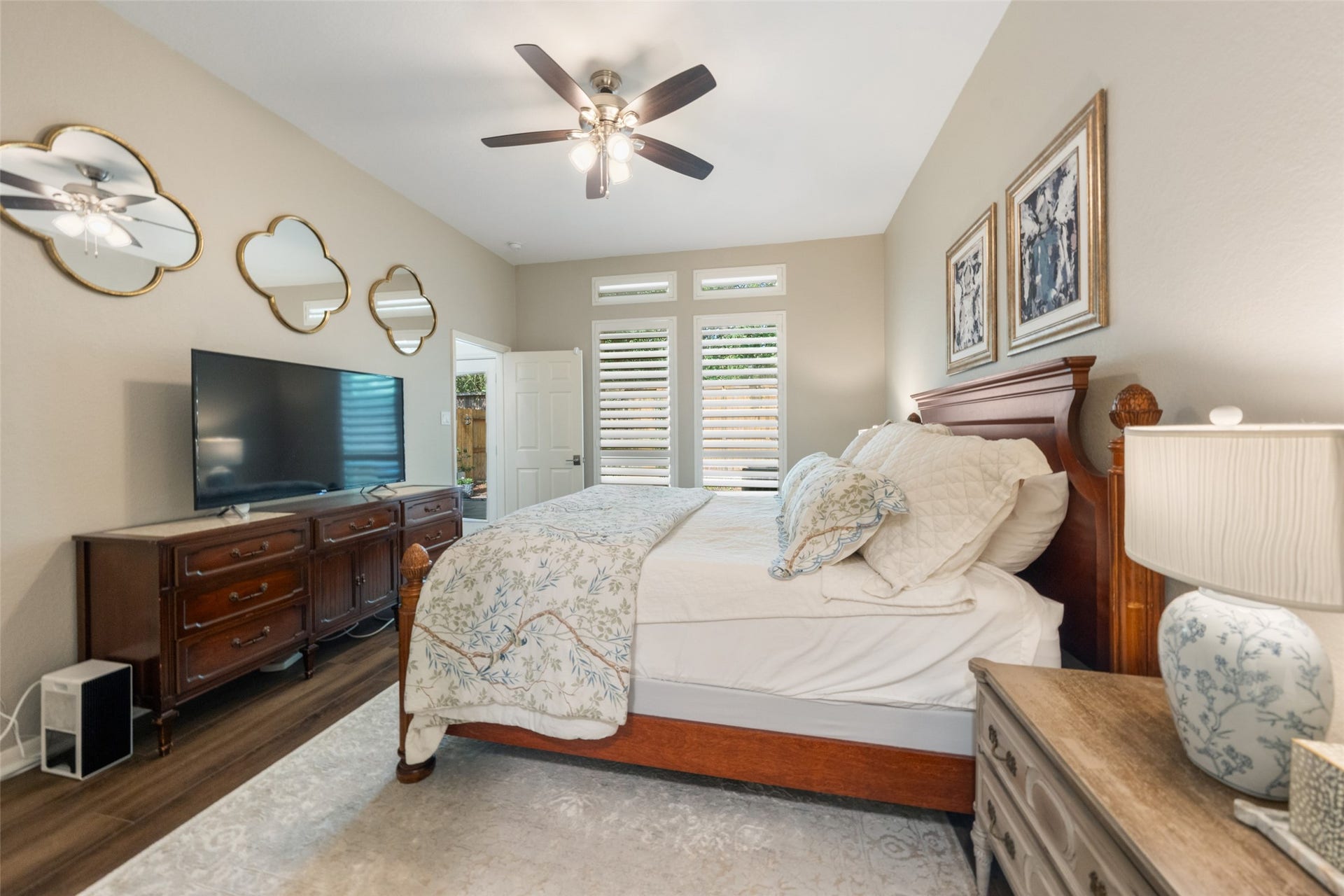 34 Alderon Woods Place, The Woodlands, TX 77382 Spacious bedroom with stylish mirrored accents, and ample natural light from large windows.
