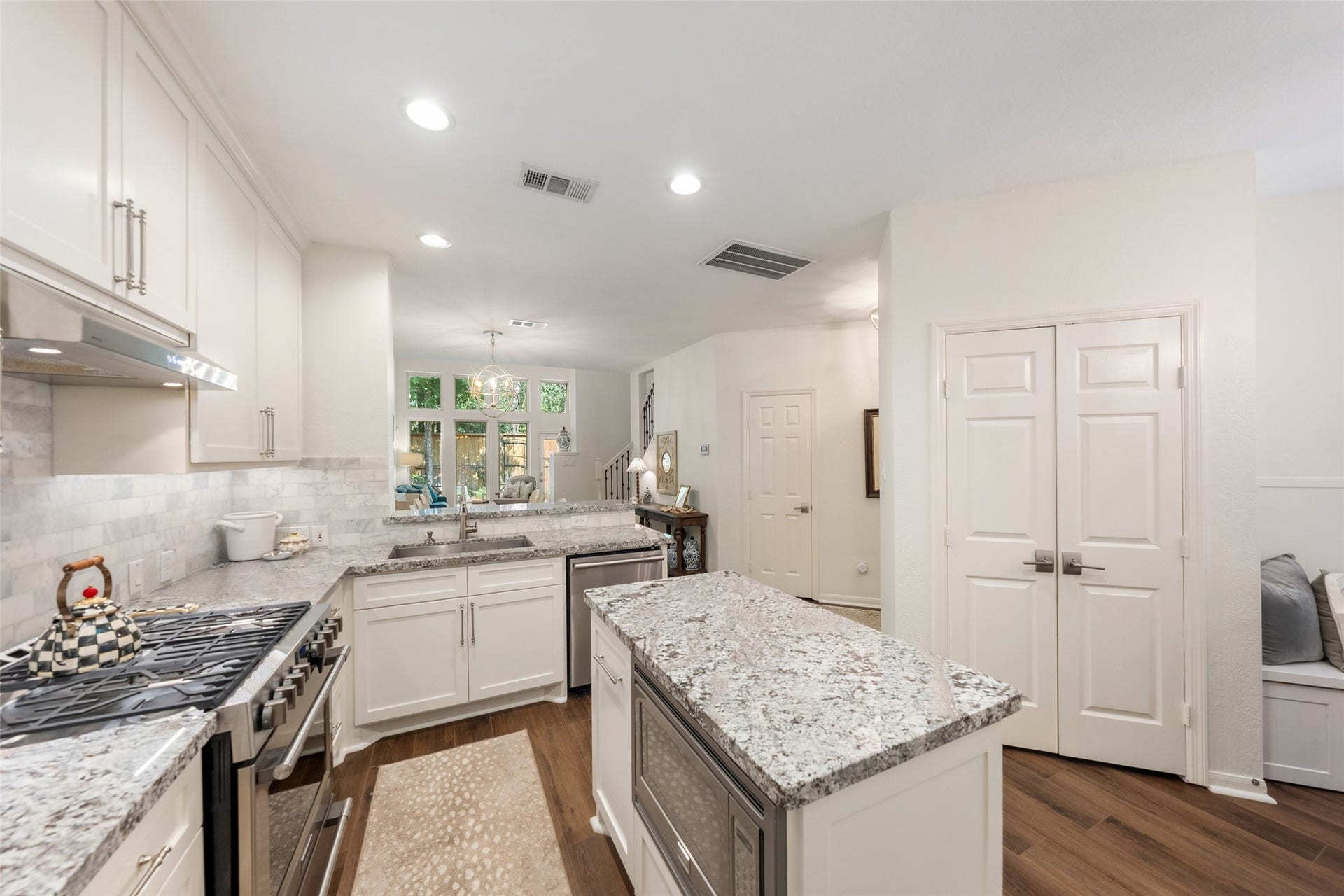 34 Alderon Woods Place, The Woodlands, TX 77382 Bright and inviting kitchen featuring granite countertops, stainless steel appliances, and ample cabinet space, complemented by a central island perfect for meal prep and gatherings.