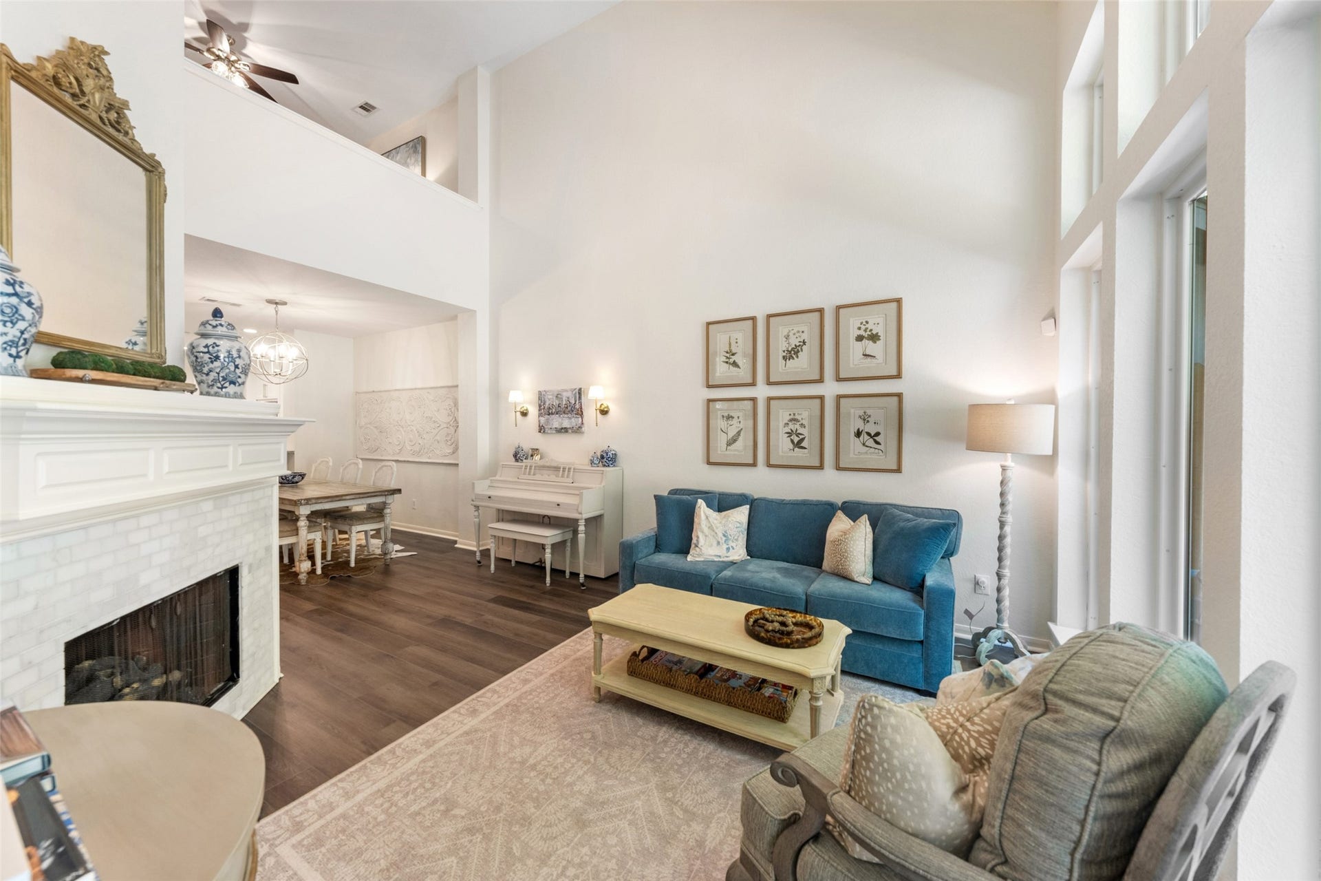 34 Alderon Woods Place, The Woodlands, TX 77382 Elegant living area with high ceilings, abundant natural light, and a cozy fireplace. The open layout seamlessly connects to a stylish dining room, creating an inviting space for relaxation and entertainment.
