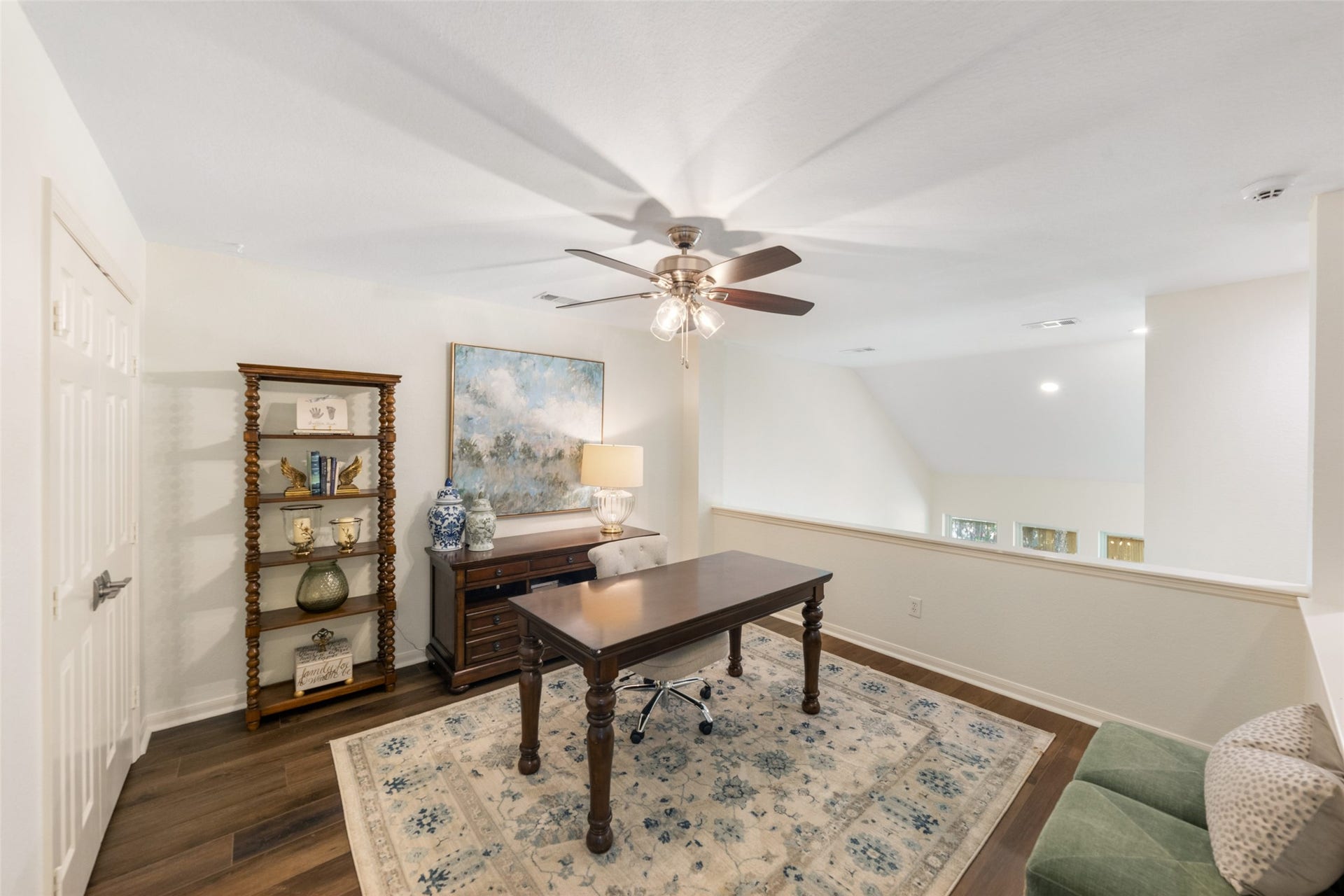 34 Alderon Woods Place, The Woodlands, TX 77382 Bright and airy loft space ideal for a home office or study, featuring hardwood floors, a built-in bookshelf, and ample natural light.