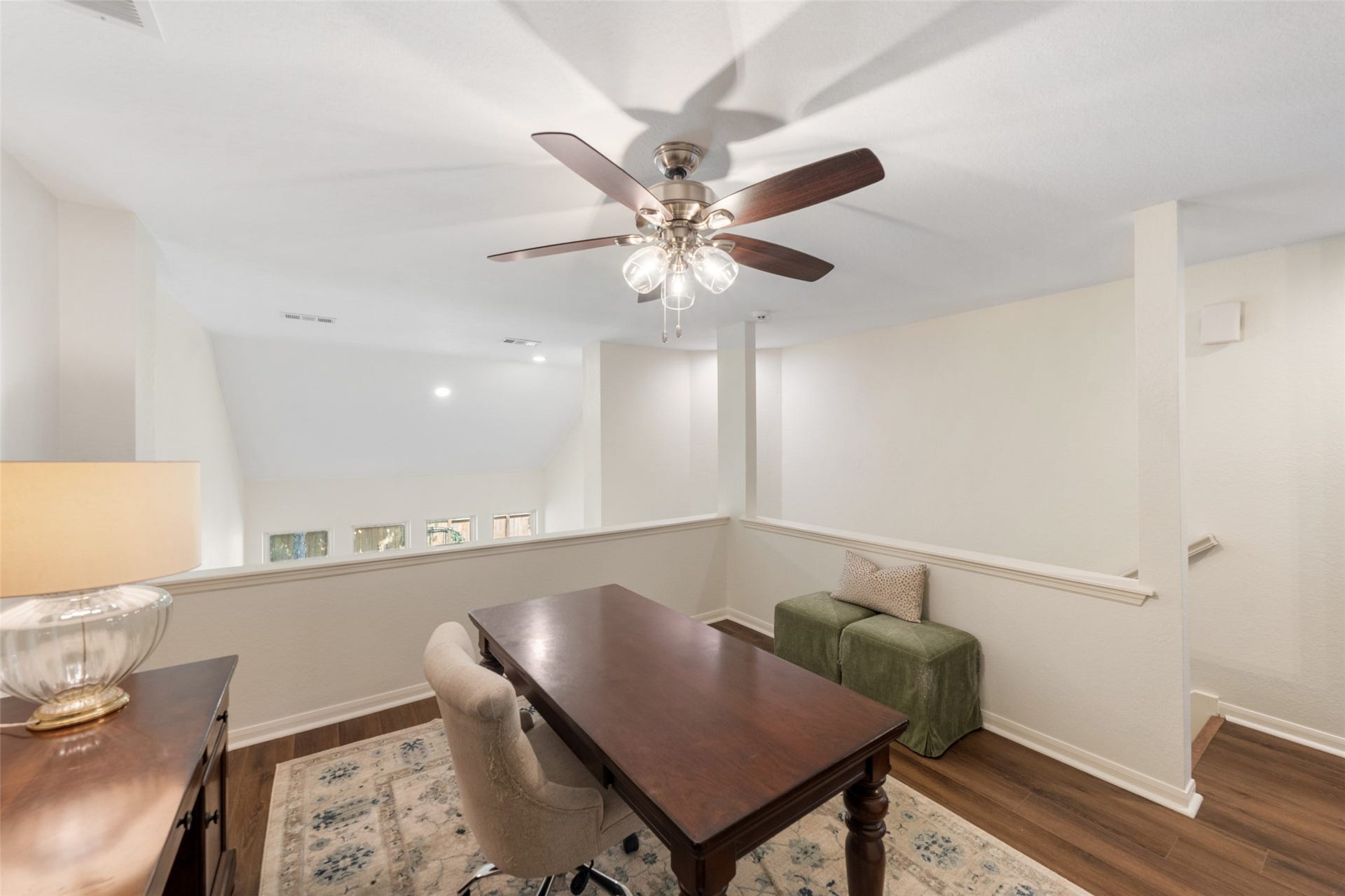 34 Alderon Woods Place, The Woodlands, TX 77382 Bright and airy loft space with a ceiling fan, perfect for a home office or reading nook, featuring elegant wood flooring and a cozy seating area.
