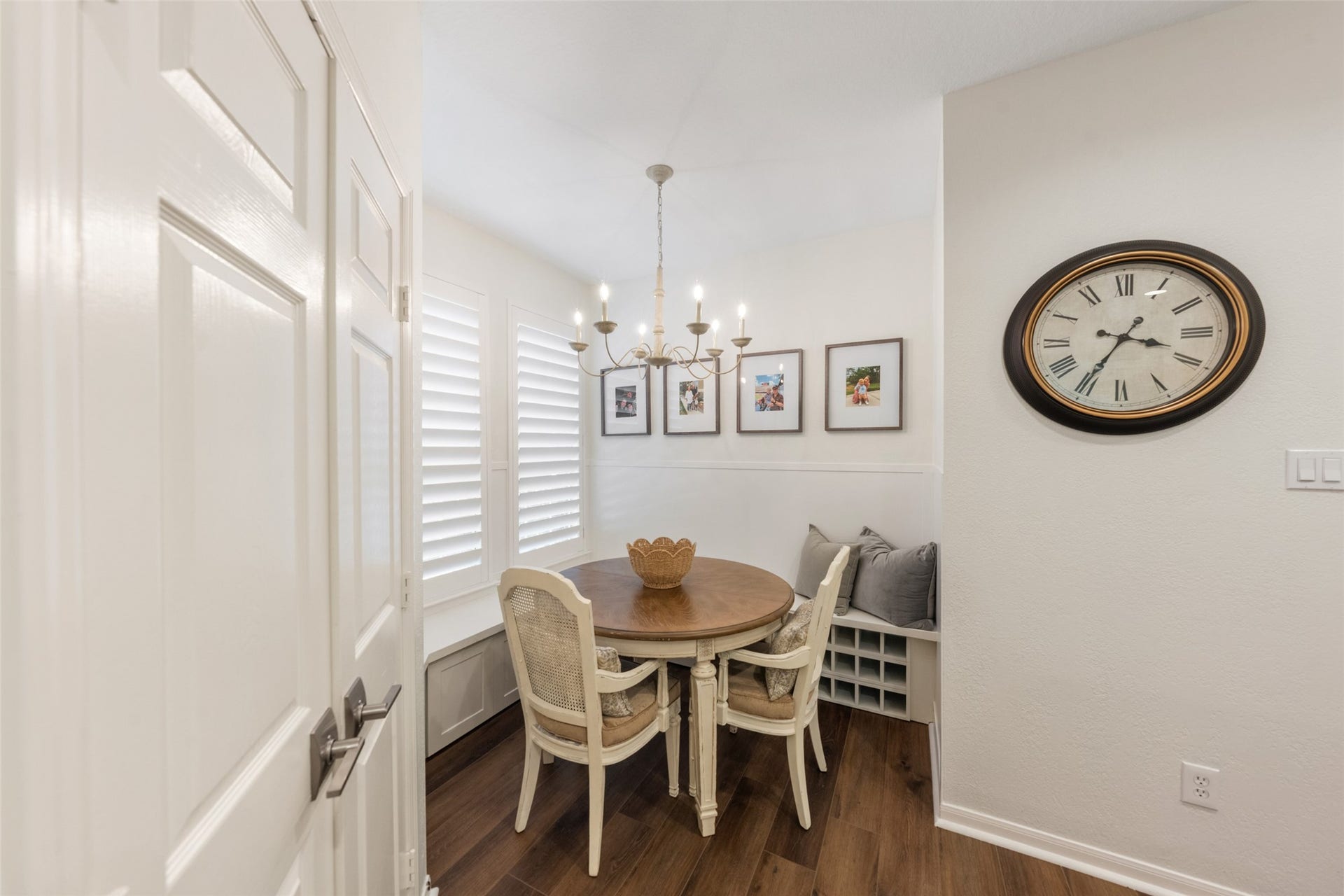 34 Alderon Woods Place, The Woodlands, TX 77382 Charming breakfast nook with a round table, elegant chandelier, and built-in seating, all framed by bright windows and tasteful decor.