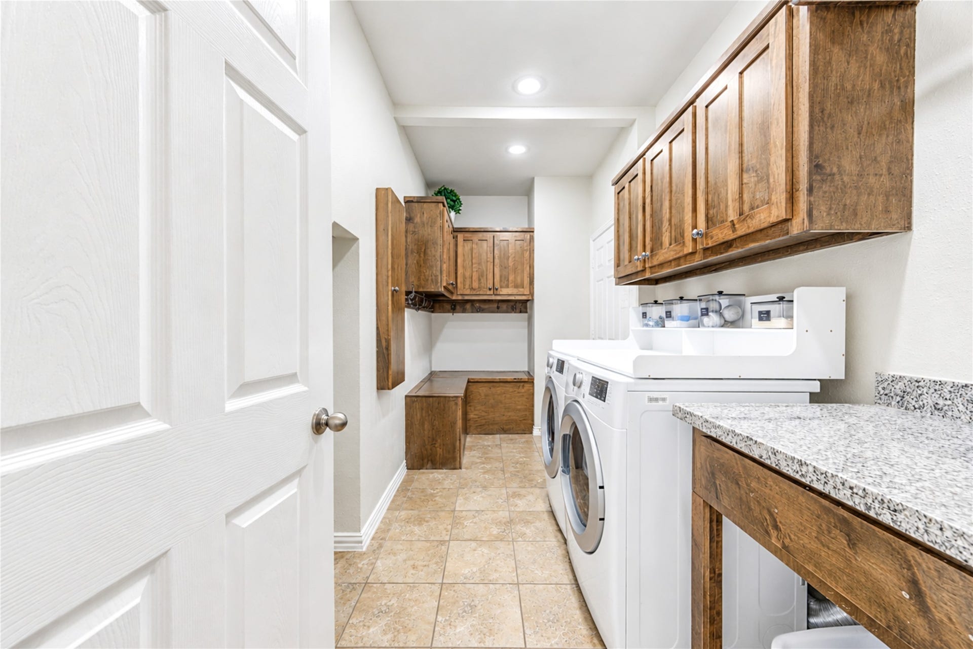 28019 Longspur Drive, Katy, TX 77494 MUD room with clothes washer and dryer. Additional storage and granite countertop to fold clothes.