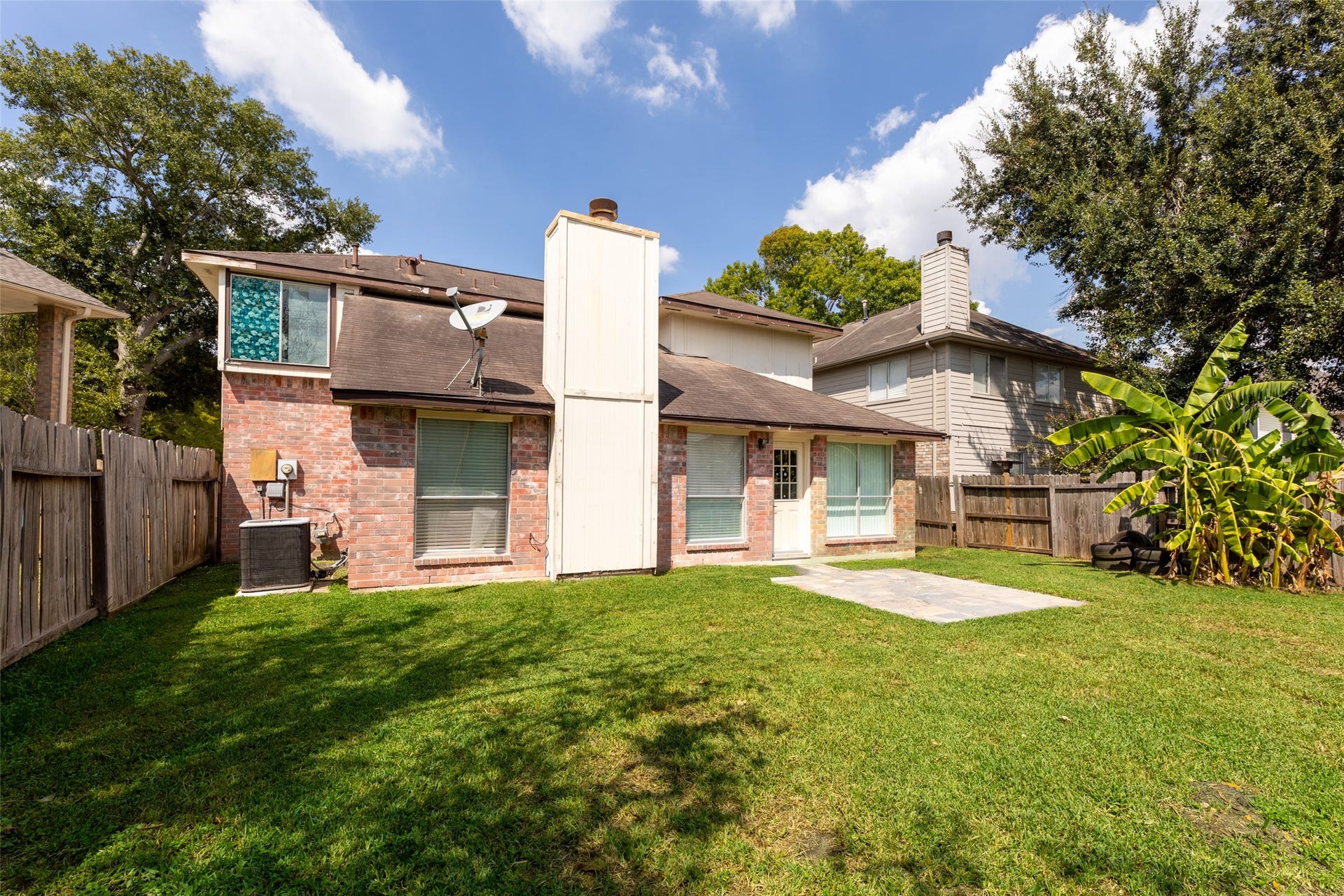 2033 Wildwood Ridge Drive, Missouri City, TX 77489 This open backyard space features mature surrounding greenery and a wide lawn area that creates a natural, peaceful retreat.