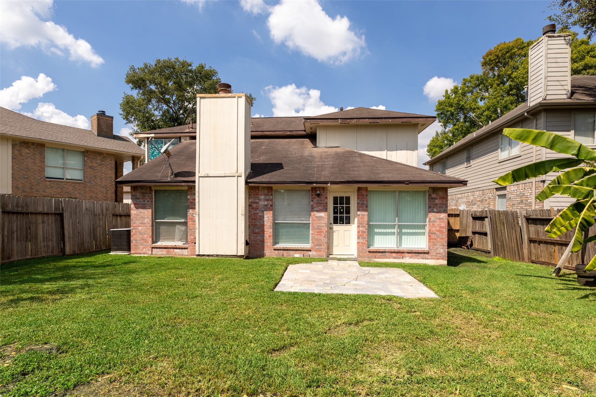 2033 Wildwood Ridge Drive, Missouri City, TX 77489 Classic brick exterior featuring a prominent chimney that adds traditional architectural character to the roofline.