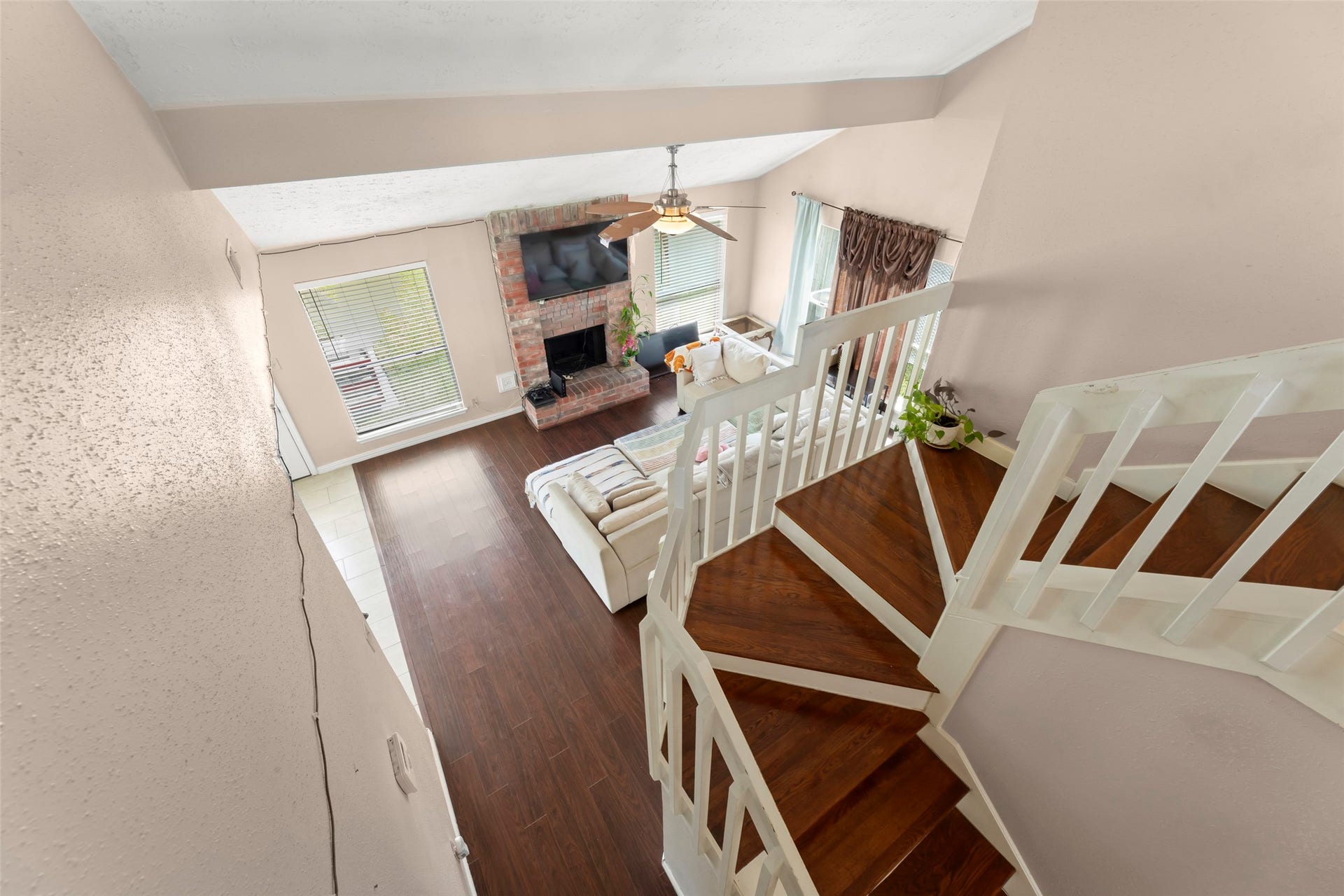 2033 Wildwood Ridge Drive, Missouri City, TX 77489 Traditional staircase showcasing rich wood treads, crisp white railings, and a striking vantage point looking down into the vaulted living room.