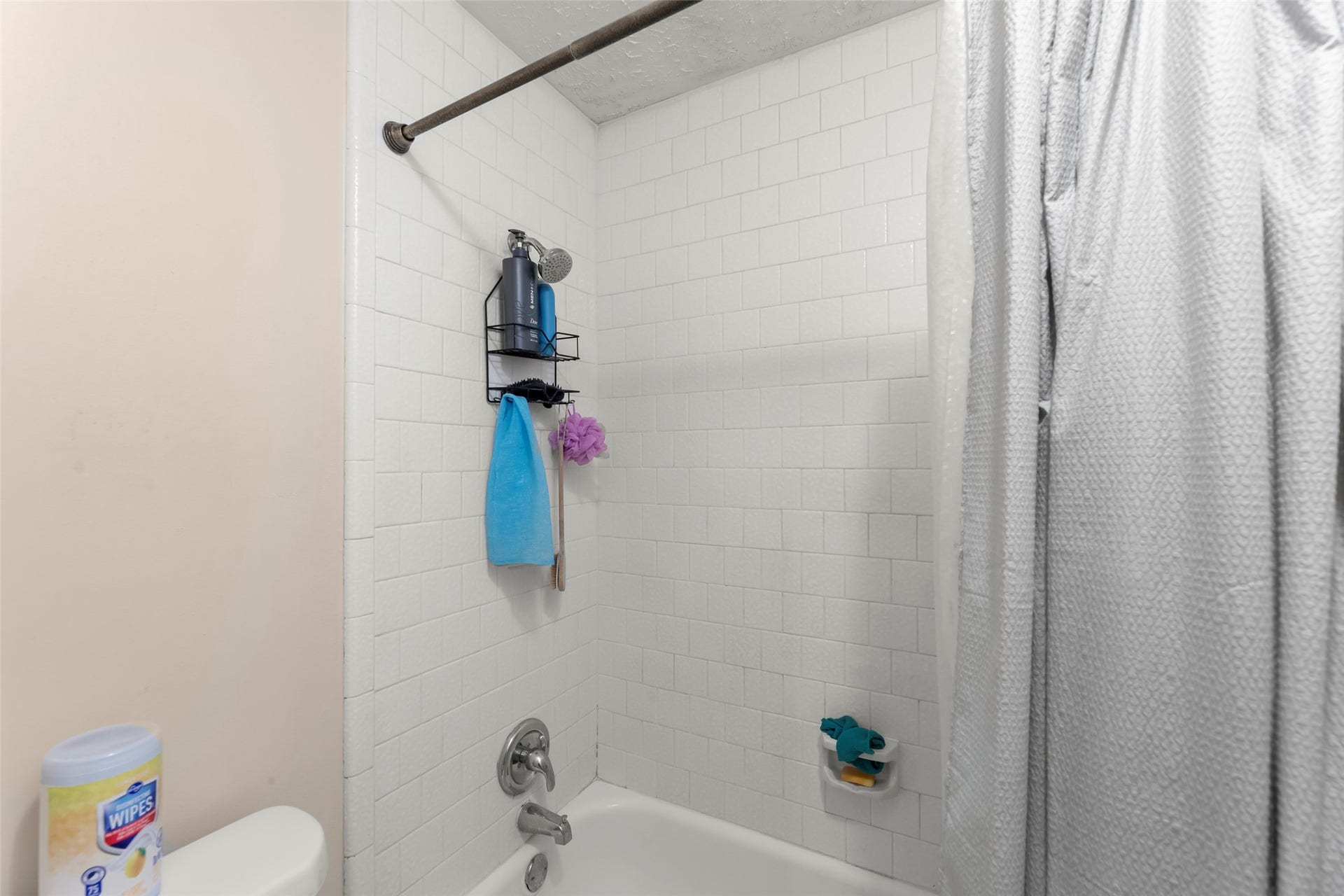 2033 Wildwood Ridge Drive, Missouri City, TX 77489 Bright and functional bathroom wet area highlighting a pristine white tile backsplash and a streamlined tub and shower pairing.