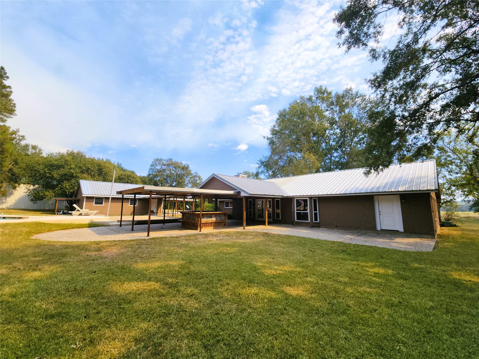 557 Fm 2693 Road E, New Waverly, TX 77358 Closer look at the back of the house with the covered outdoor bar overlooking the pool.