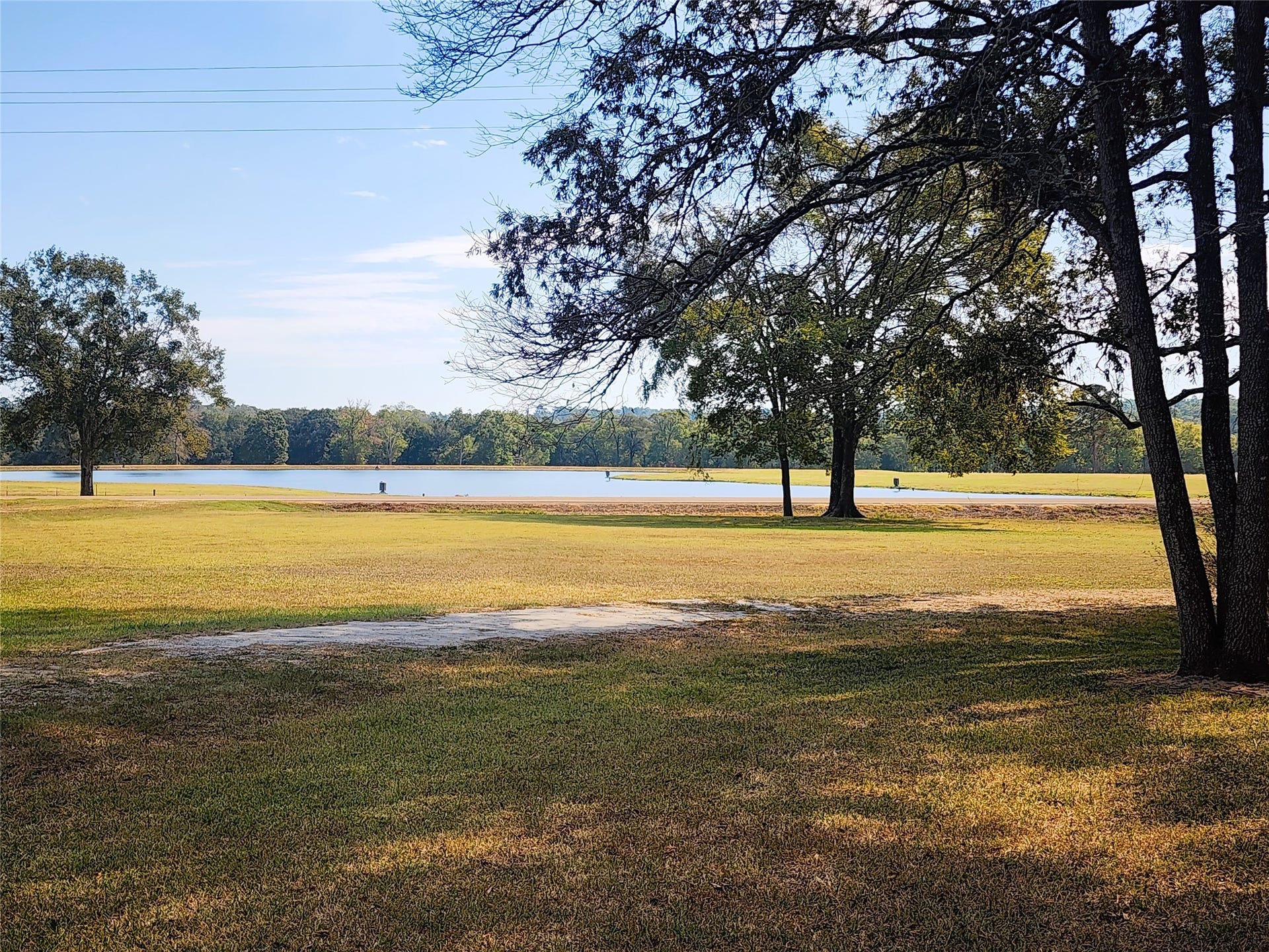 557 Fm 2693 Road E, New Waverly, TX 77358 Enjoy serene lake views across the street from this spacious, tree-lined property, perfect for outdoor relaxation and scenic beauty.