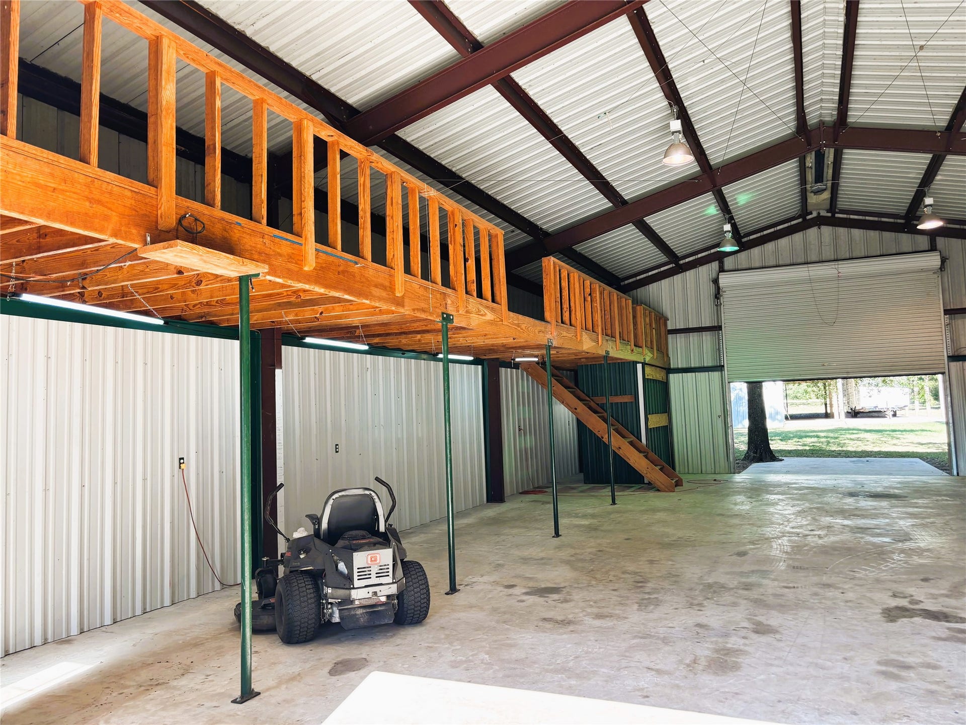 557 Fm 2693 Road E, New Waverly, TX 77358 Spacious metal workshop with high ceilings, featuring a wooden loft the entire length of the building.